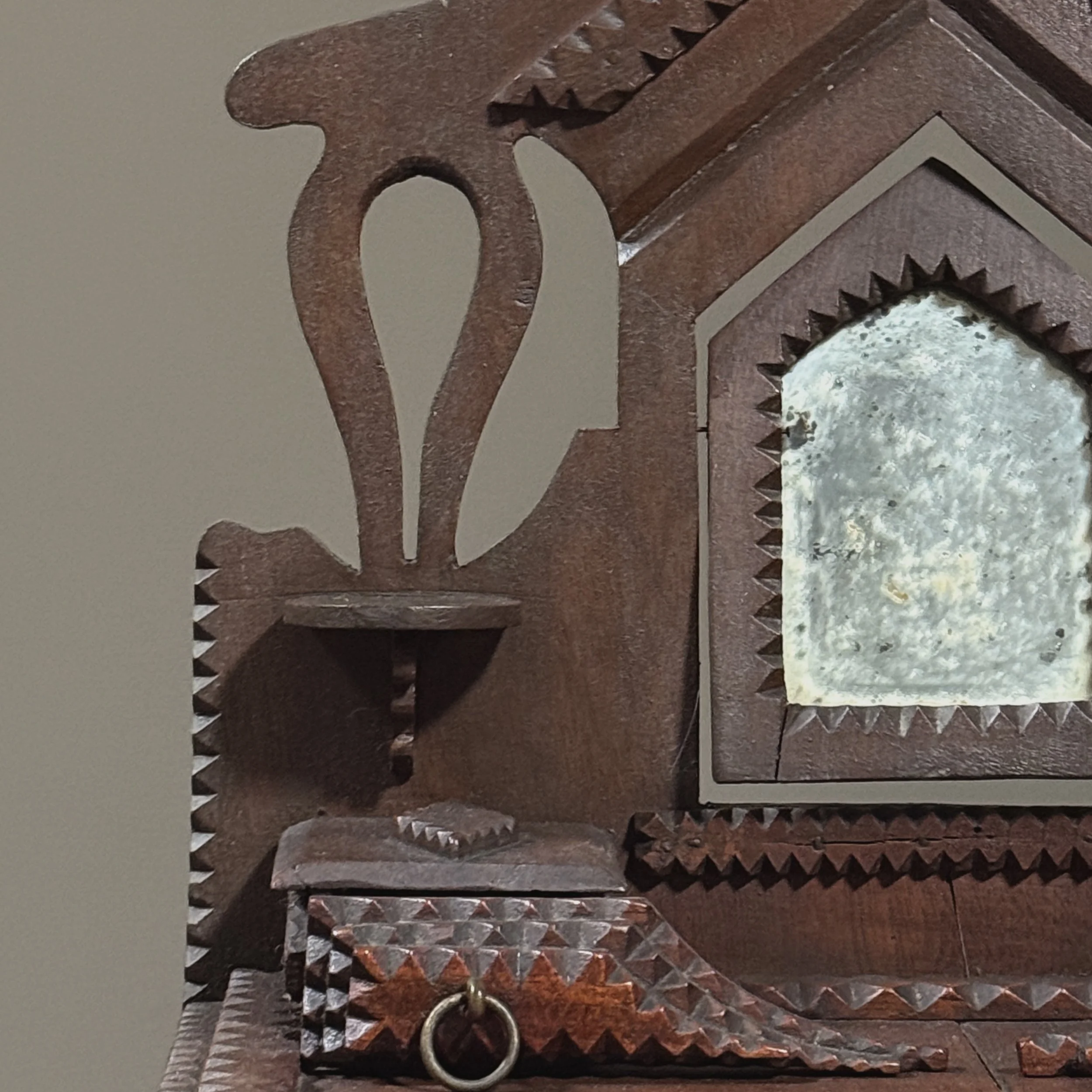 Horseshoe-shaped carvings on backboard beside mirror