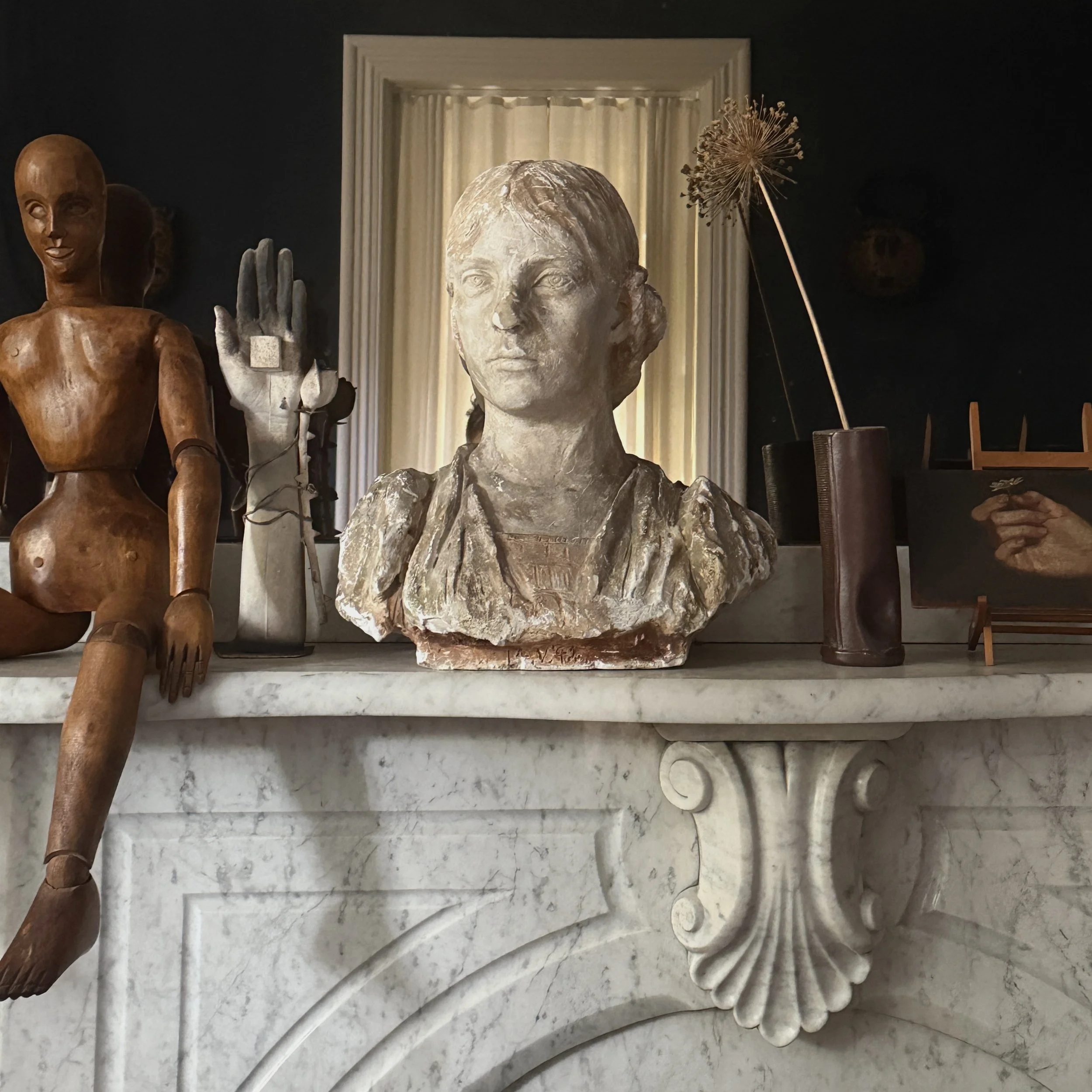 Antique Classical Revival female bust with braided hair, staged vignette.
