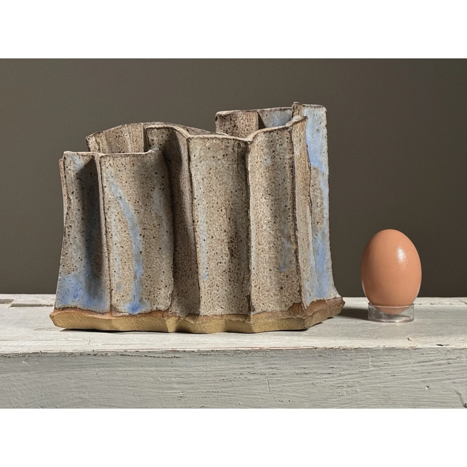 Front view of a Seiko Kato Behr postmodernist ceramic ikebana vase with an egg for size reference