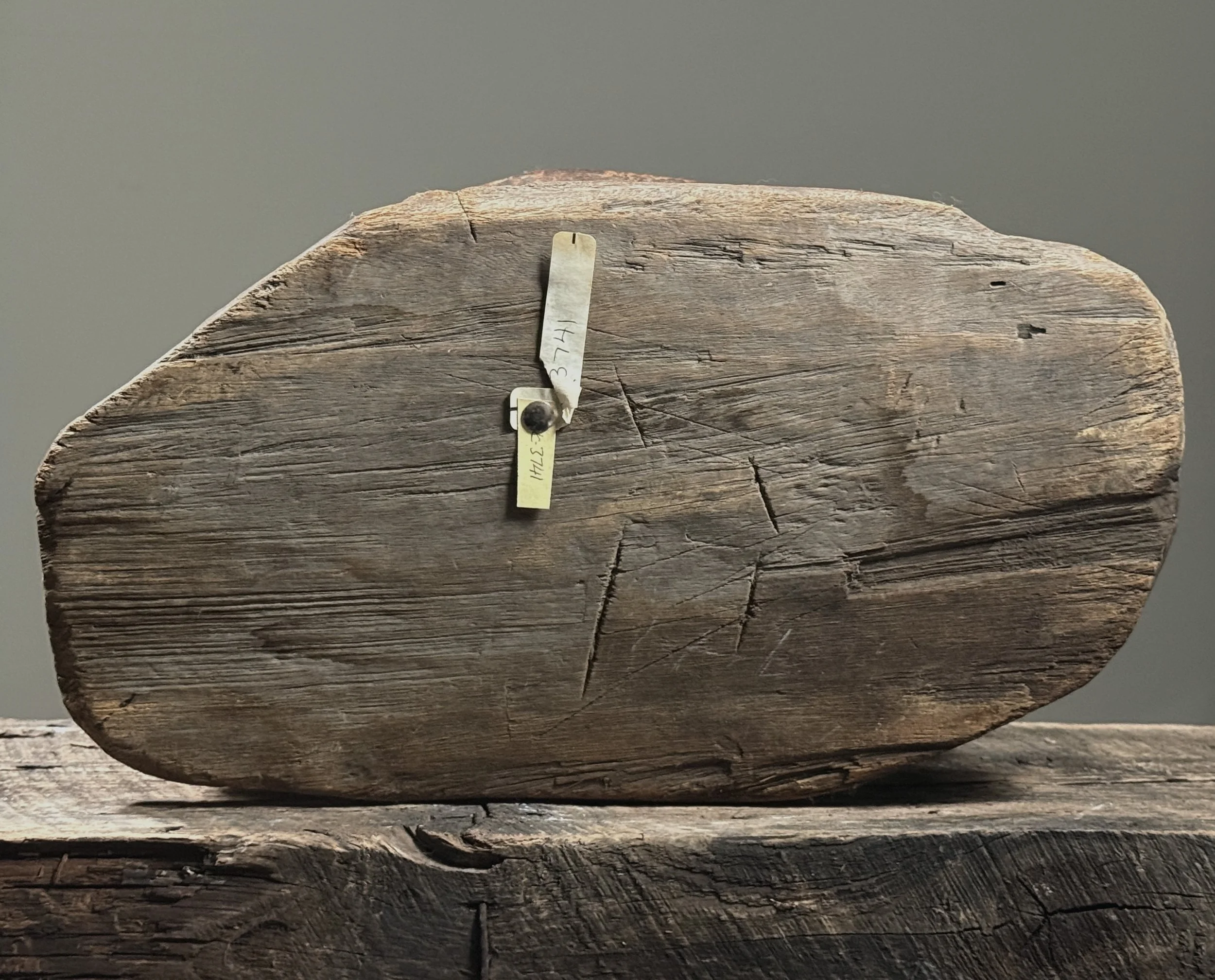 Detail of the original museum tags affixed to the underside of the stool