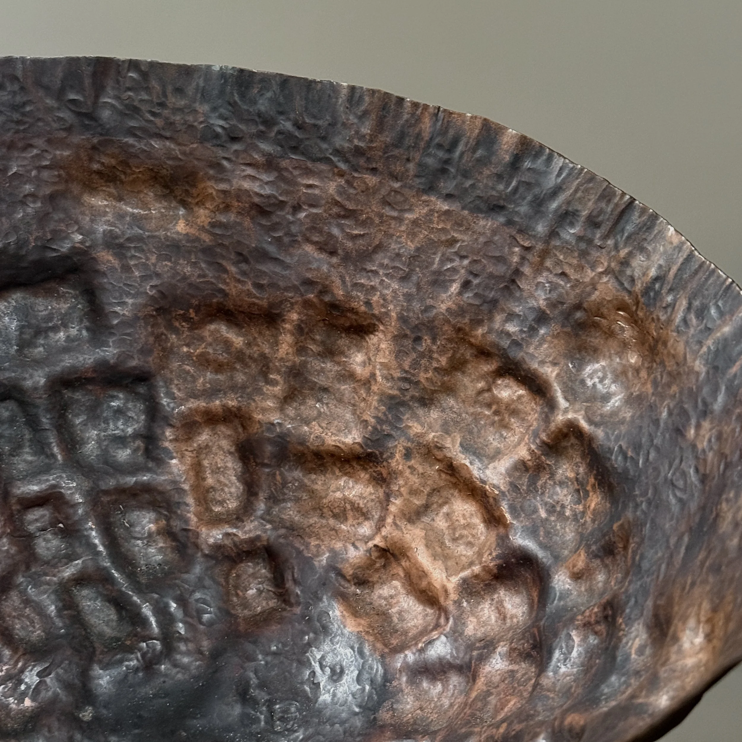 Texture close-up showing the rich burgundy and verdigris patina on copper.