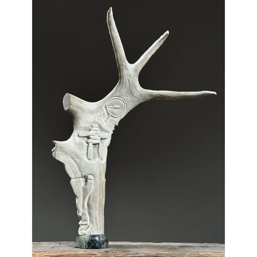 Full view of a vintage Inuit folk art antler sculpture with figures and moon.