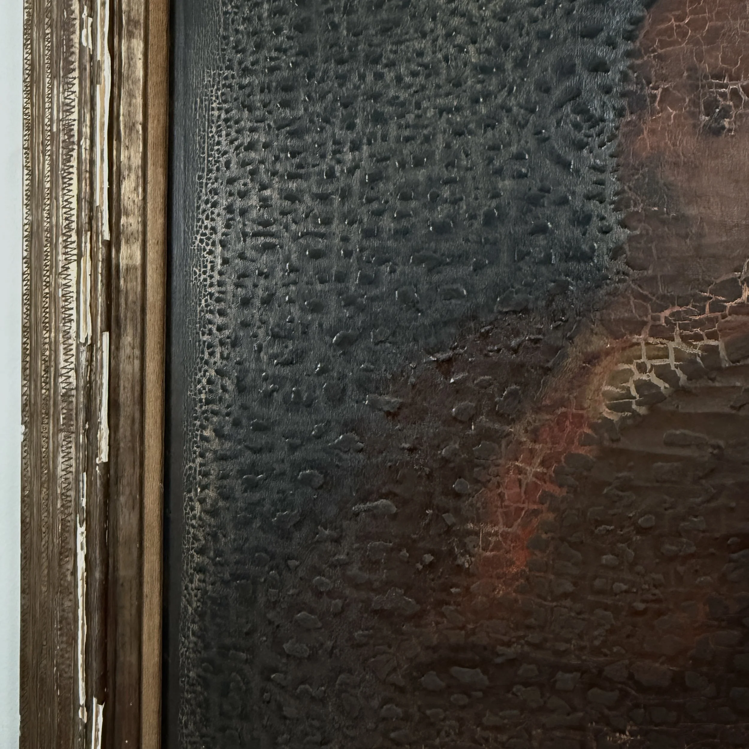 View of the hand-carved wood frame, showing decorative motifs and wear.