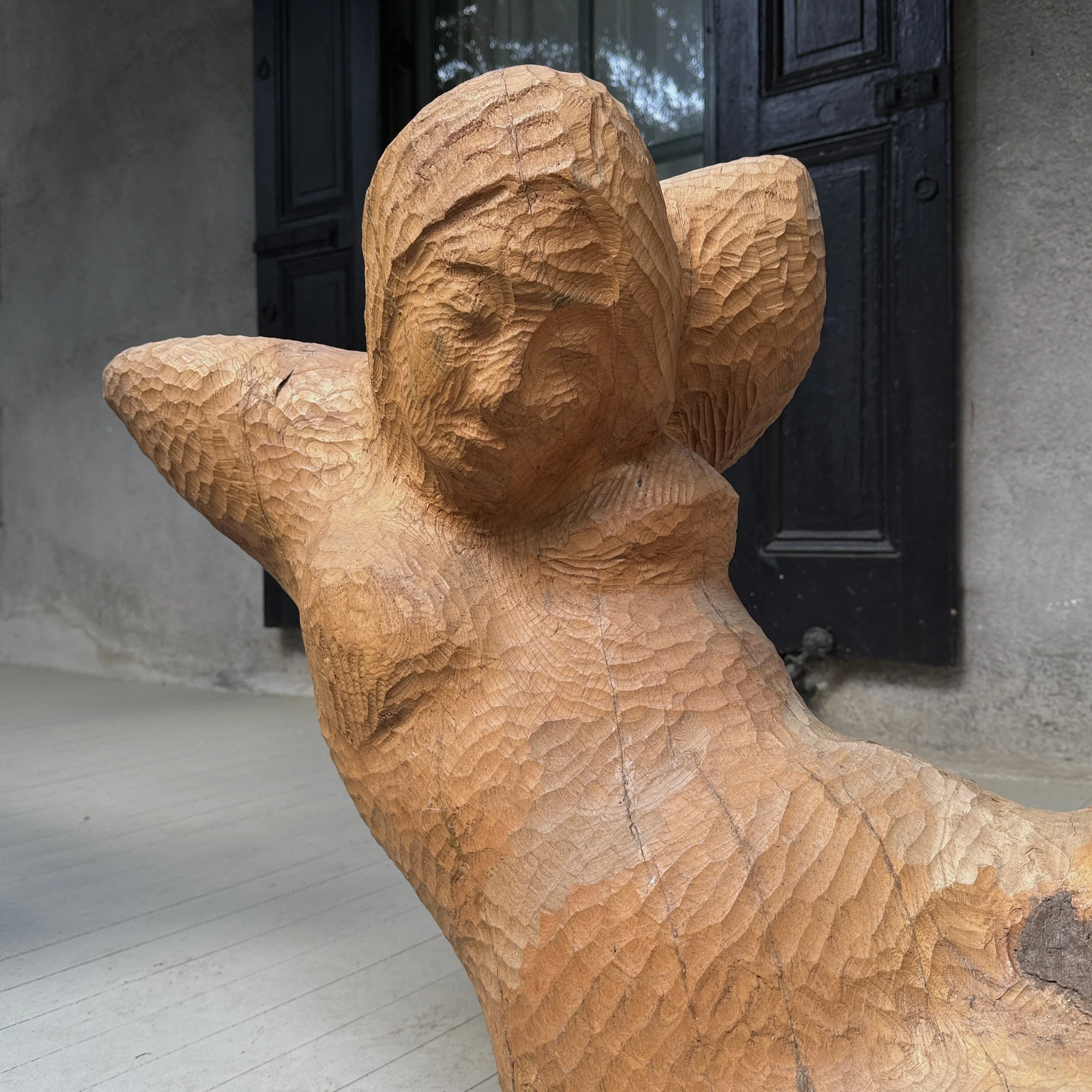 Detail of the figure's arms and torso demonstrating direct carving technique