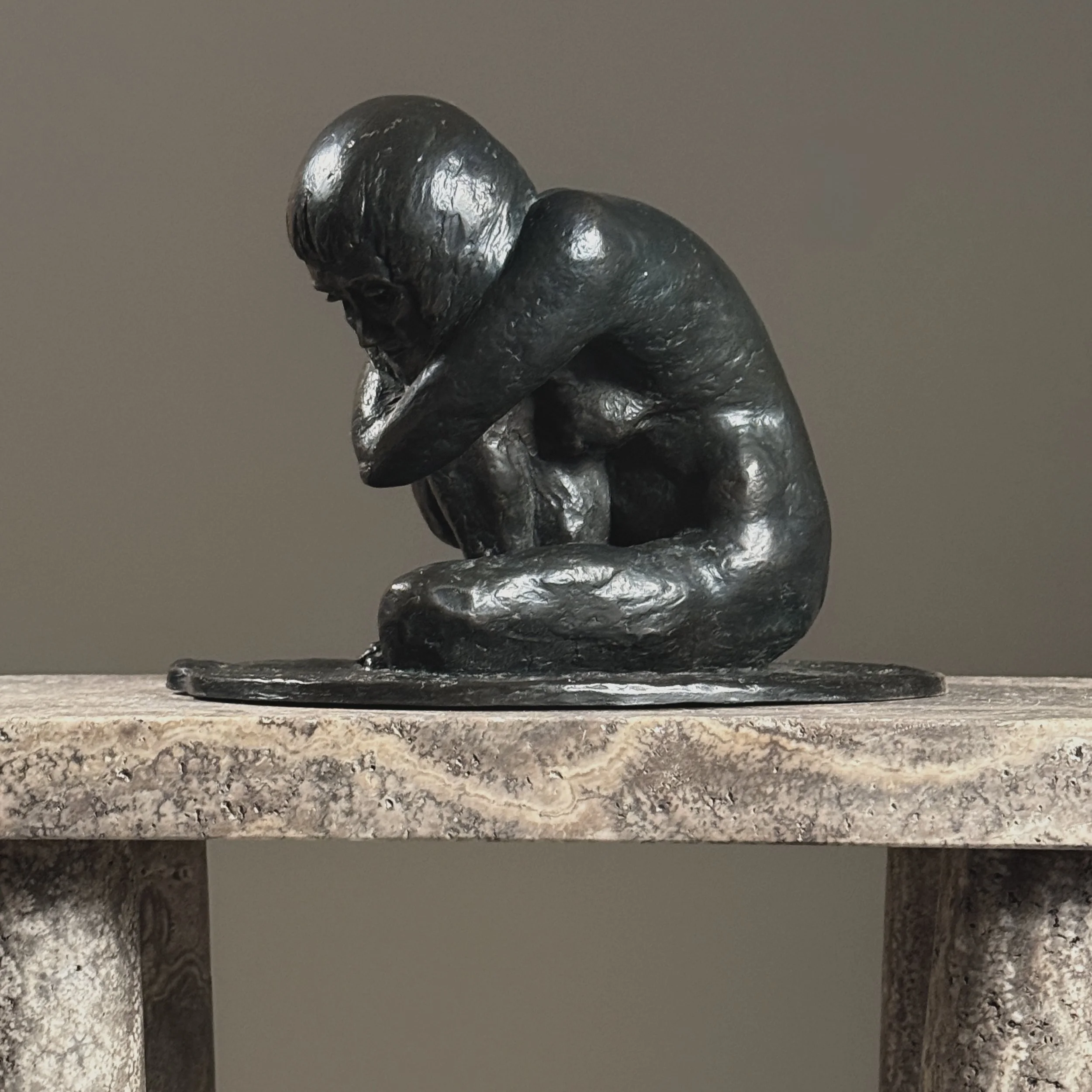 Side profile of a vintage bronze crouching nude sculpture by American artist Alma Helbig Hobson
