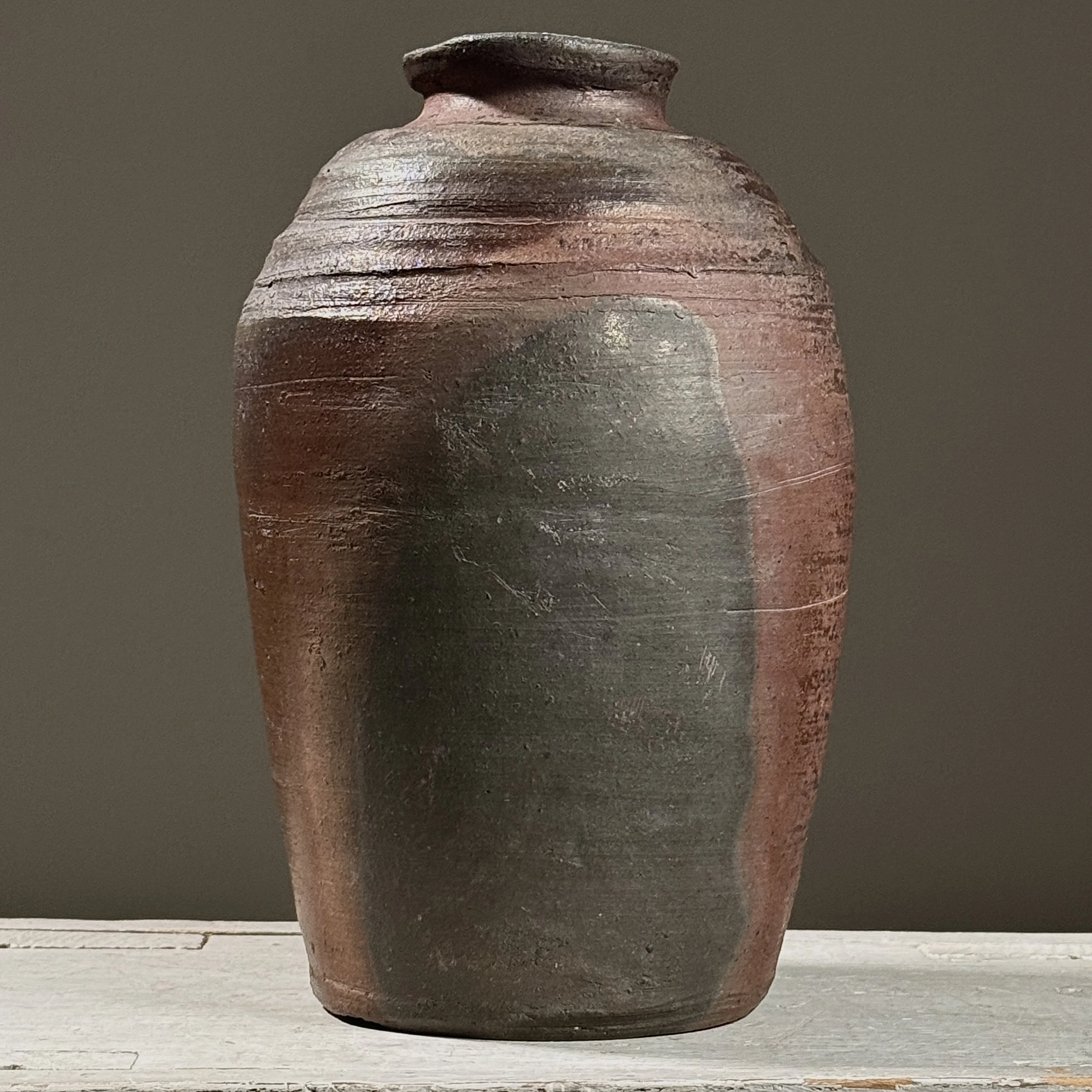 Front view of a vintage wabi-sabi wood-fired stoneware vessel.