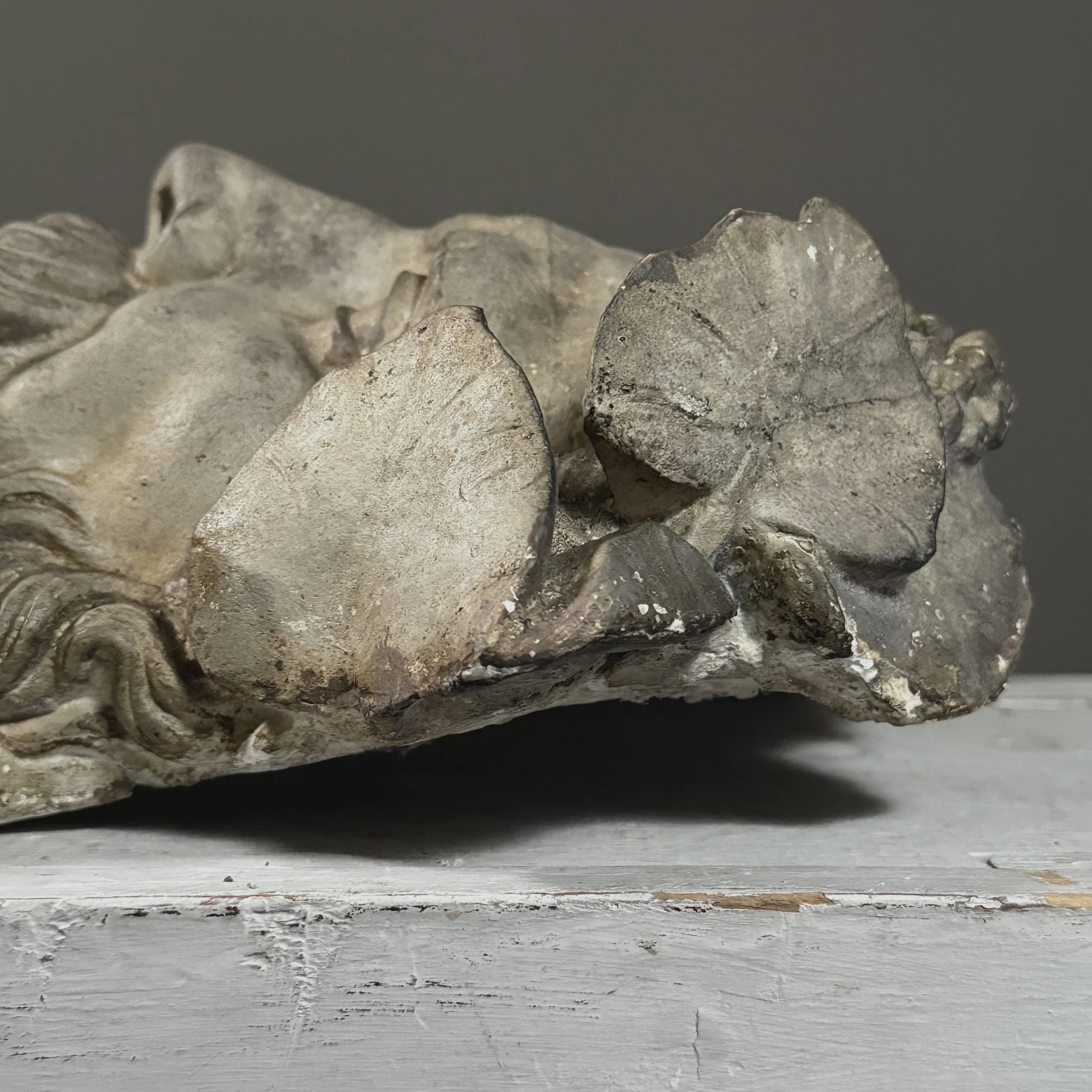 Detail of the side of the face and wreath from a close, angled perspective.