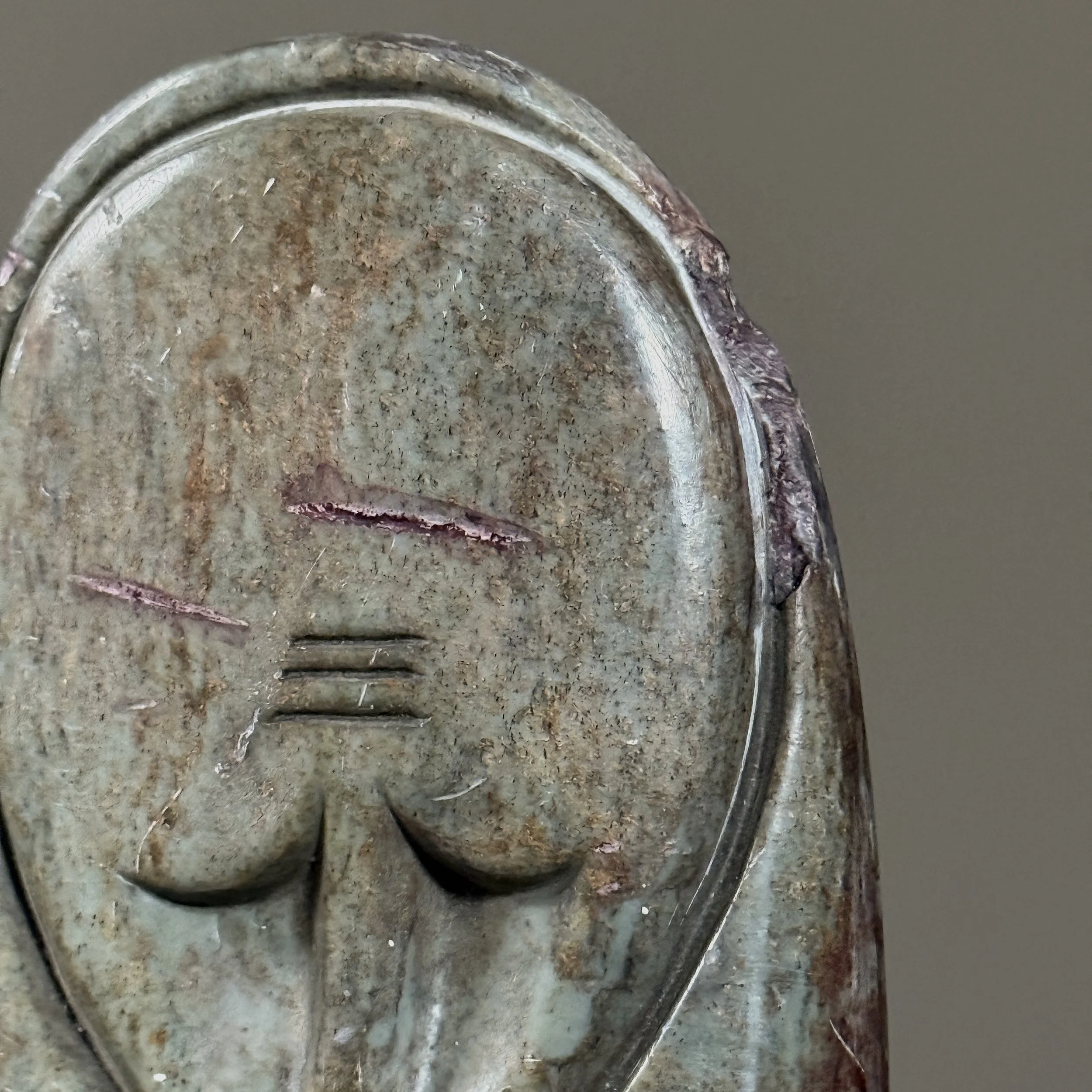 Close-up of carved face with small chip on right side