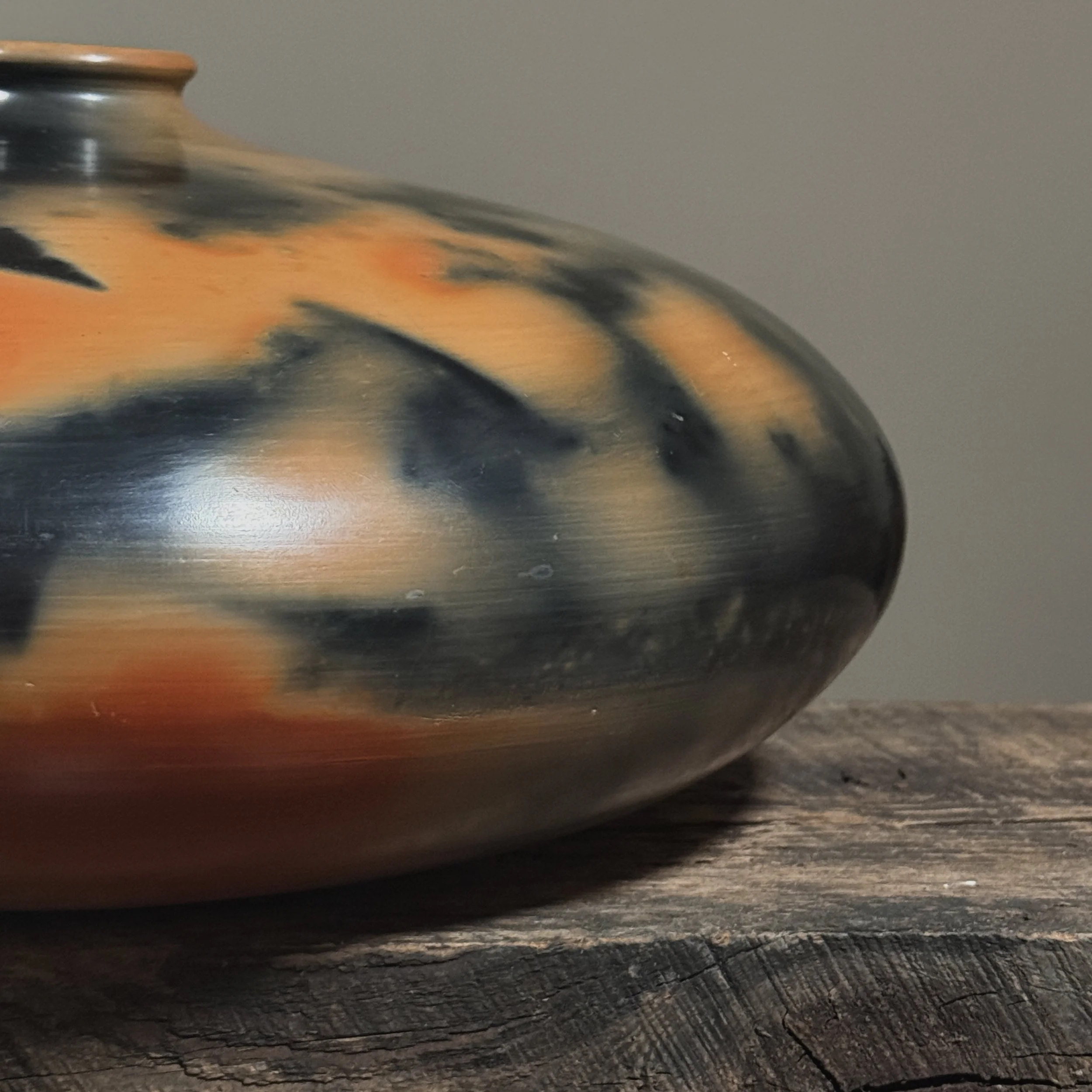Detail of burnished orange and black surface on hand-turned vessel.