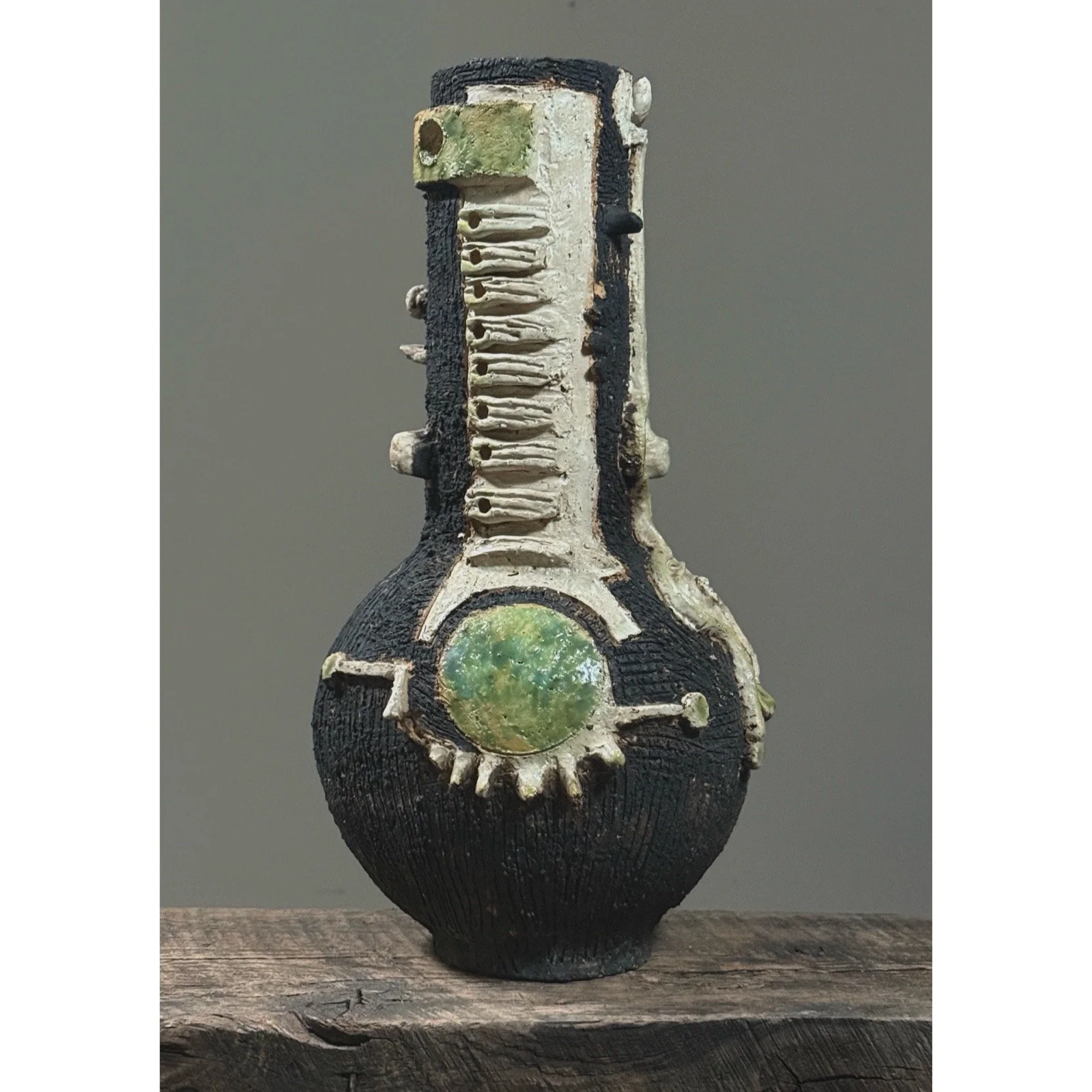 Postmodern black pottery vase with skeletal surrealist aesthetic.