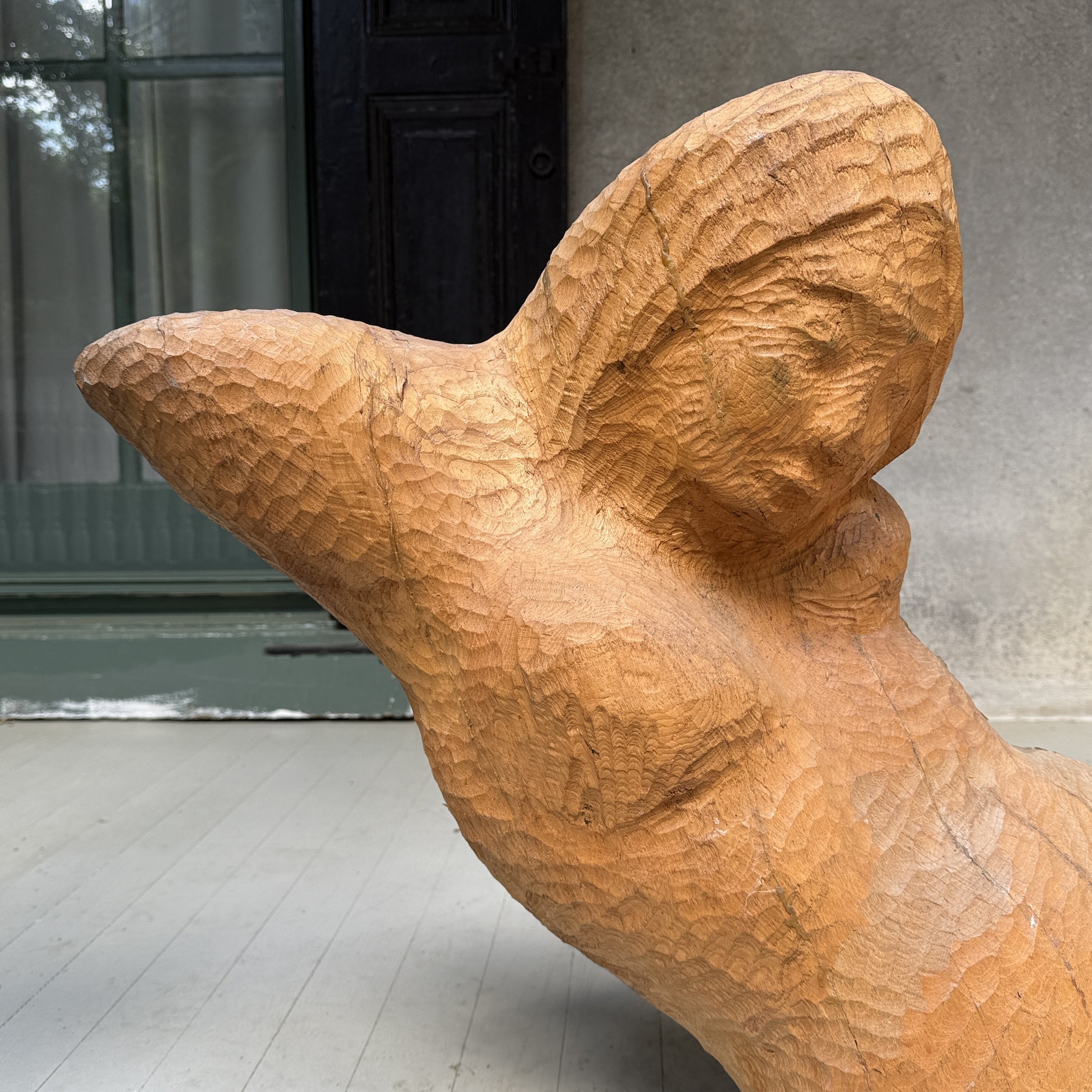 Detail of the figure's arms and torso demonstrating direct carving technique