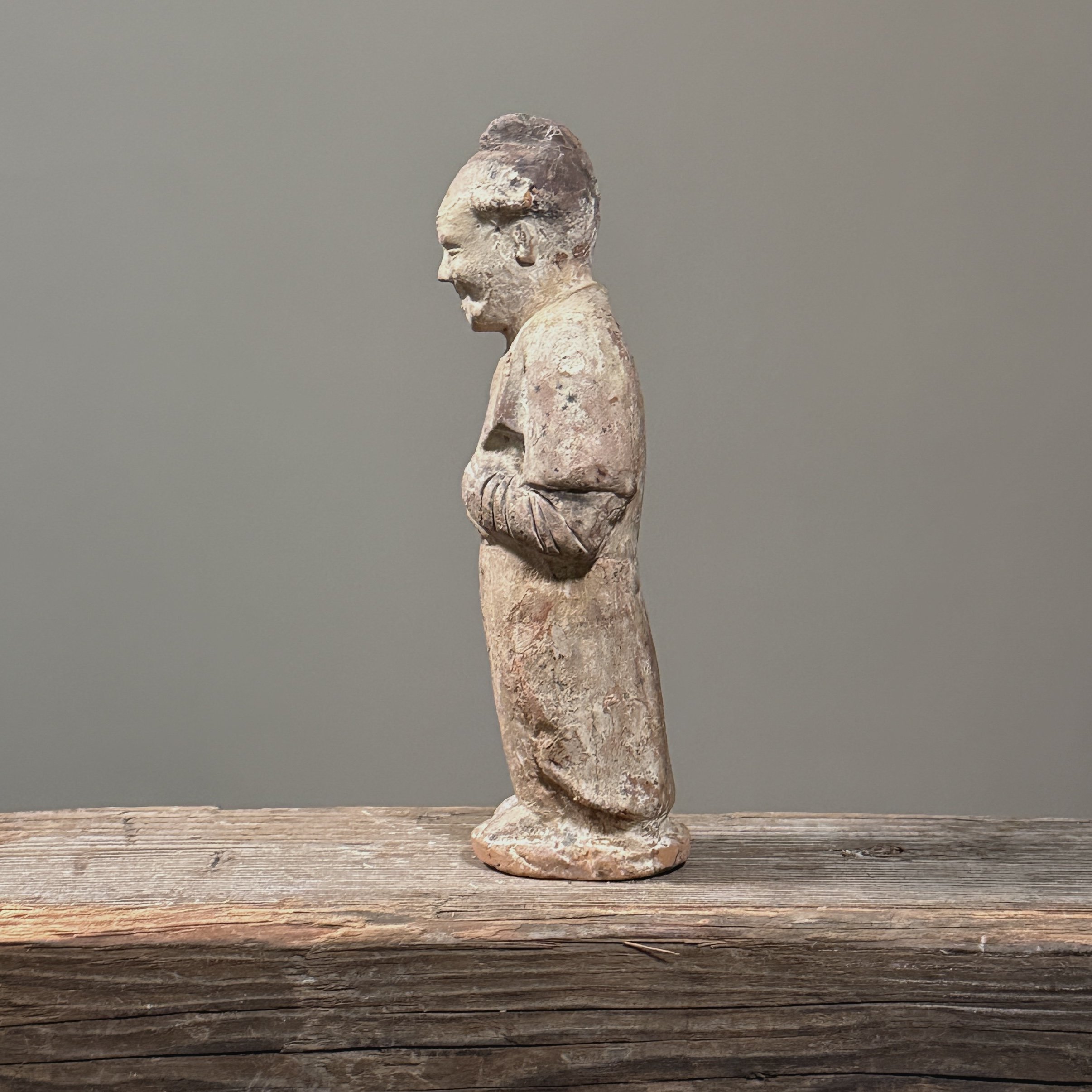 View of the figure's side, highlighting the simplified contours of the robe and form