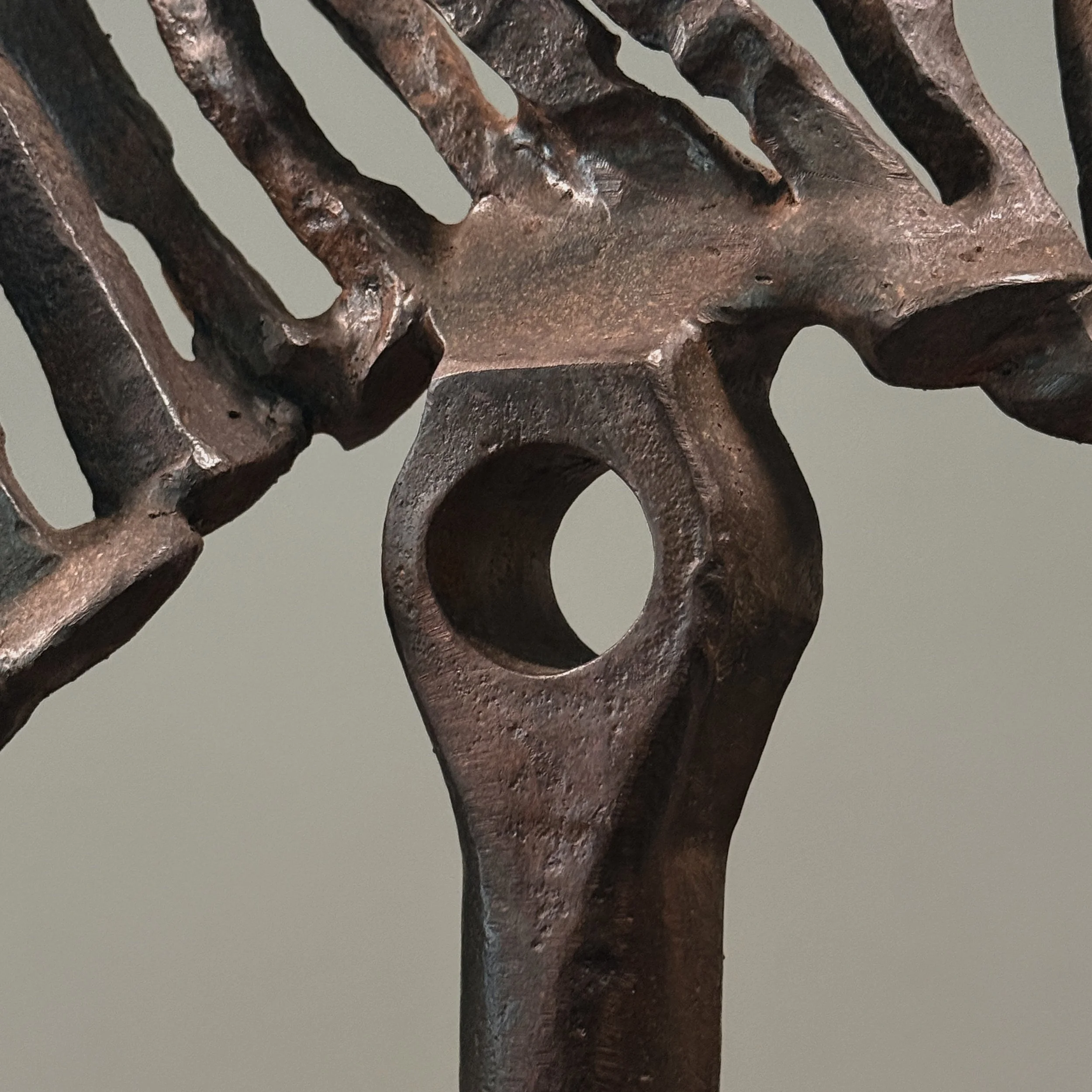 Close-up of forged iron elements. Raw material texture and industrial finish visible.