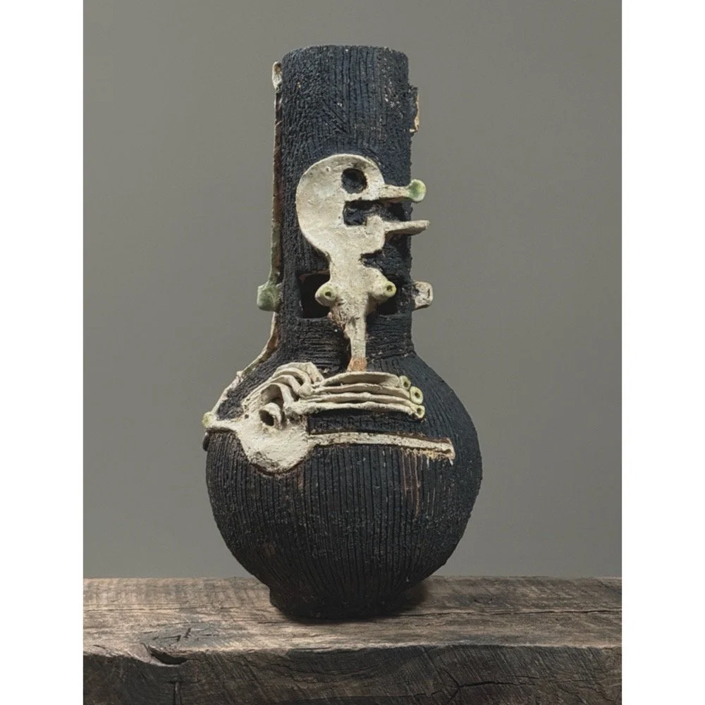 Brutalist Raku ceramic vase with abstract skeletal design and skull motif.