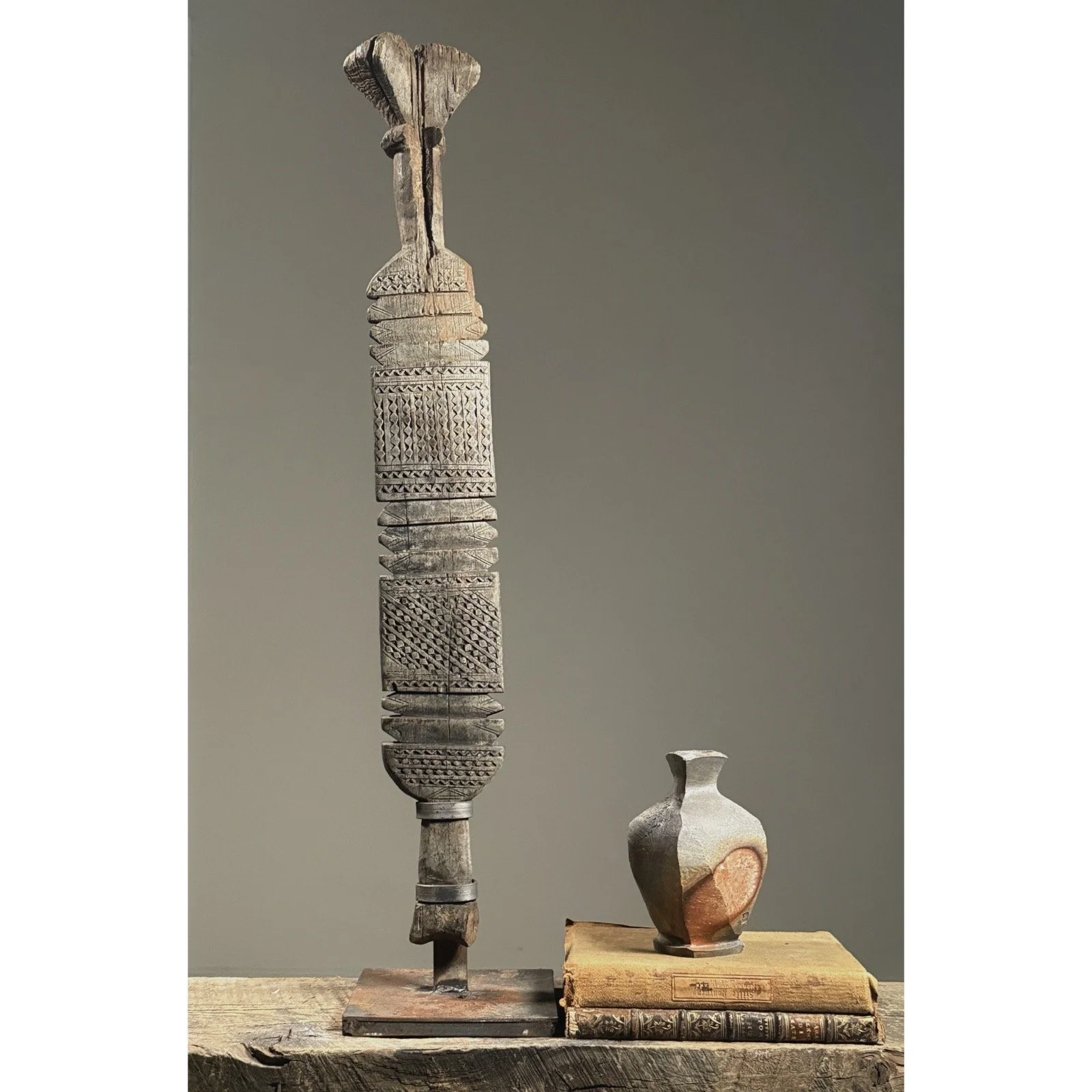 Full view of an antique Tuareg hand-carved wooden tent pole on custom iron stand.