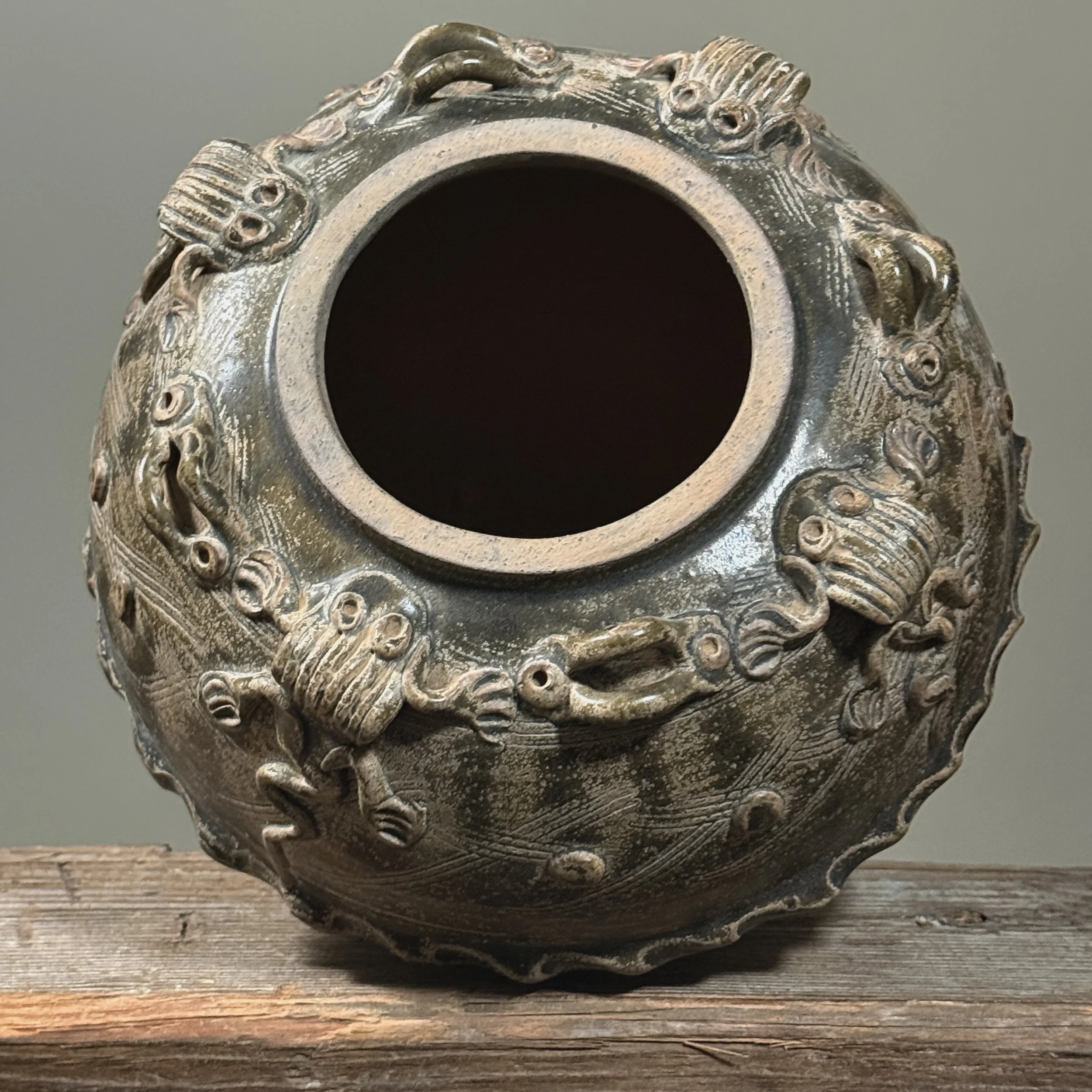 Top-down view of the rim with applied frog motifs.