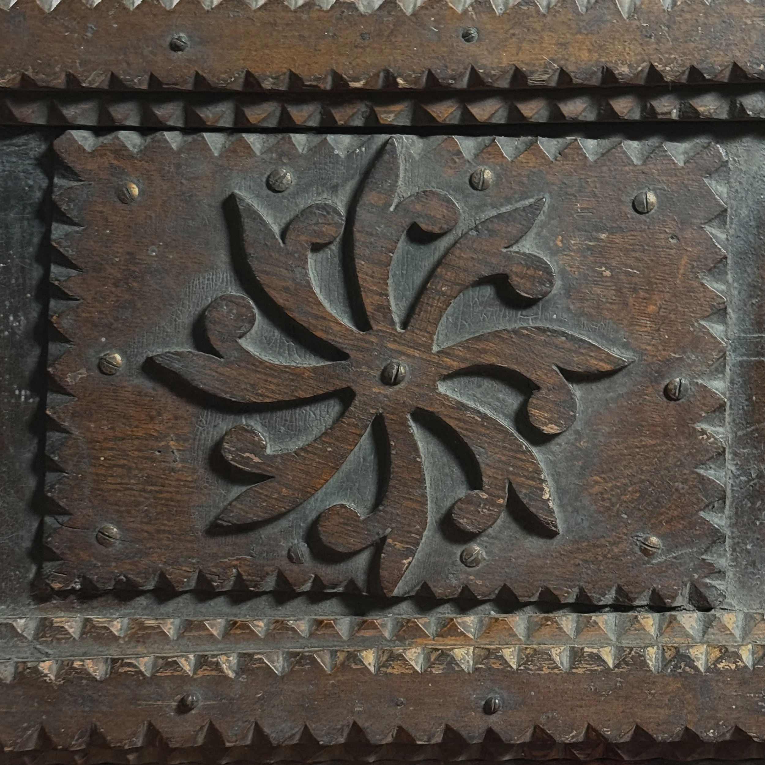 Detail shot of the central scrollwork medallion on the chest's lid.