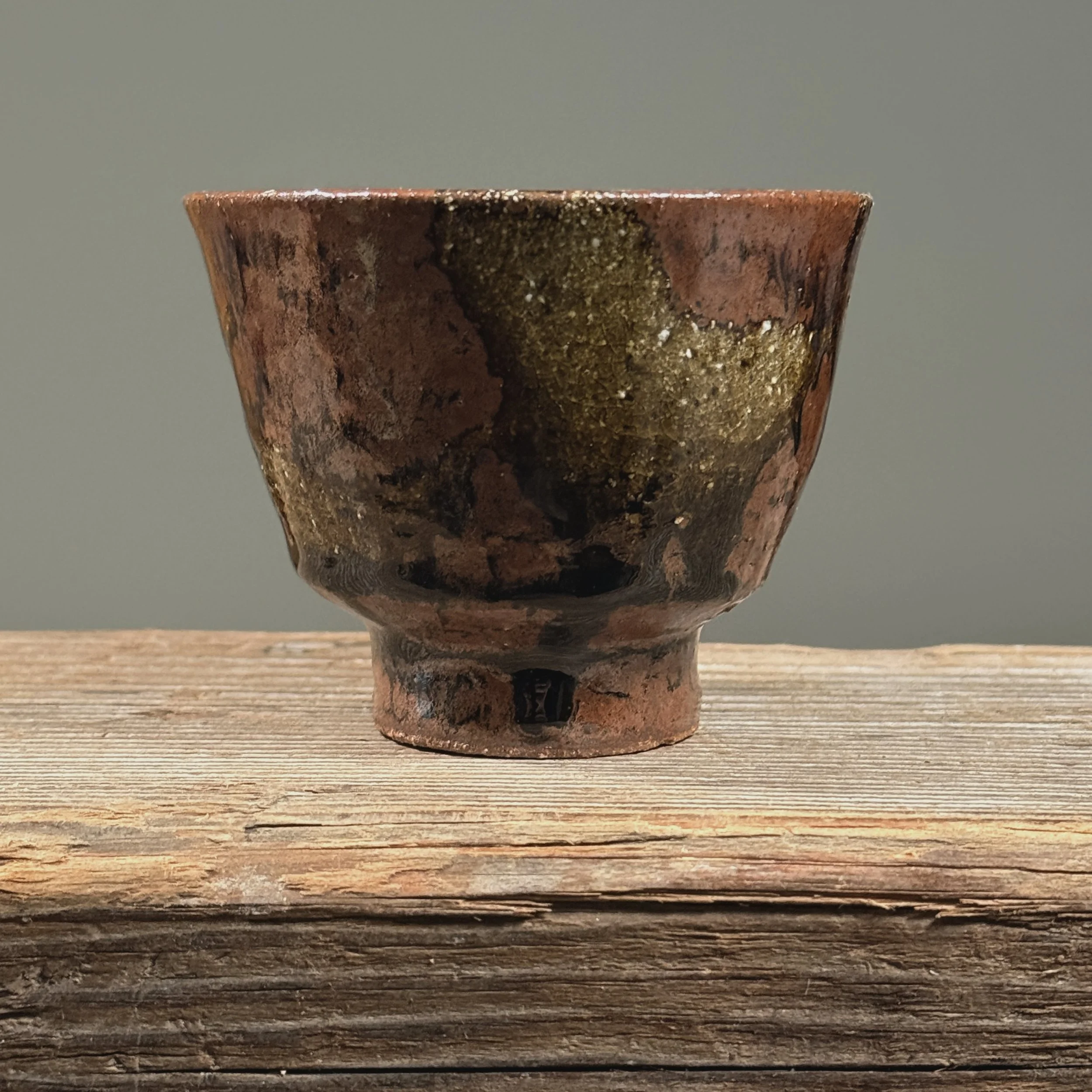 Brown glossy drip yunomi cup. Vertical glaze drips on warm brown stoneware. Unglazed foot ring exposed.