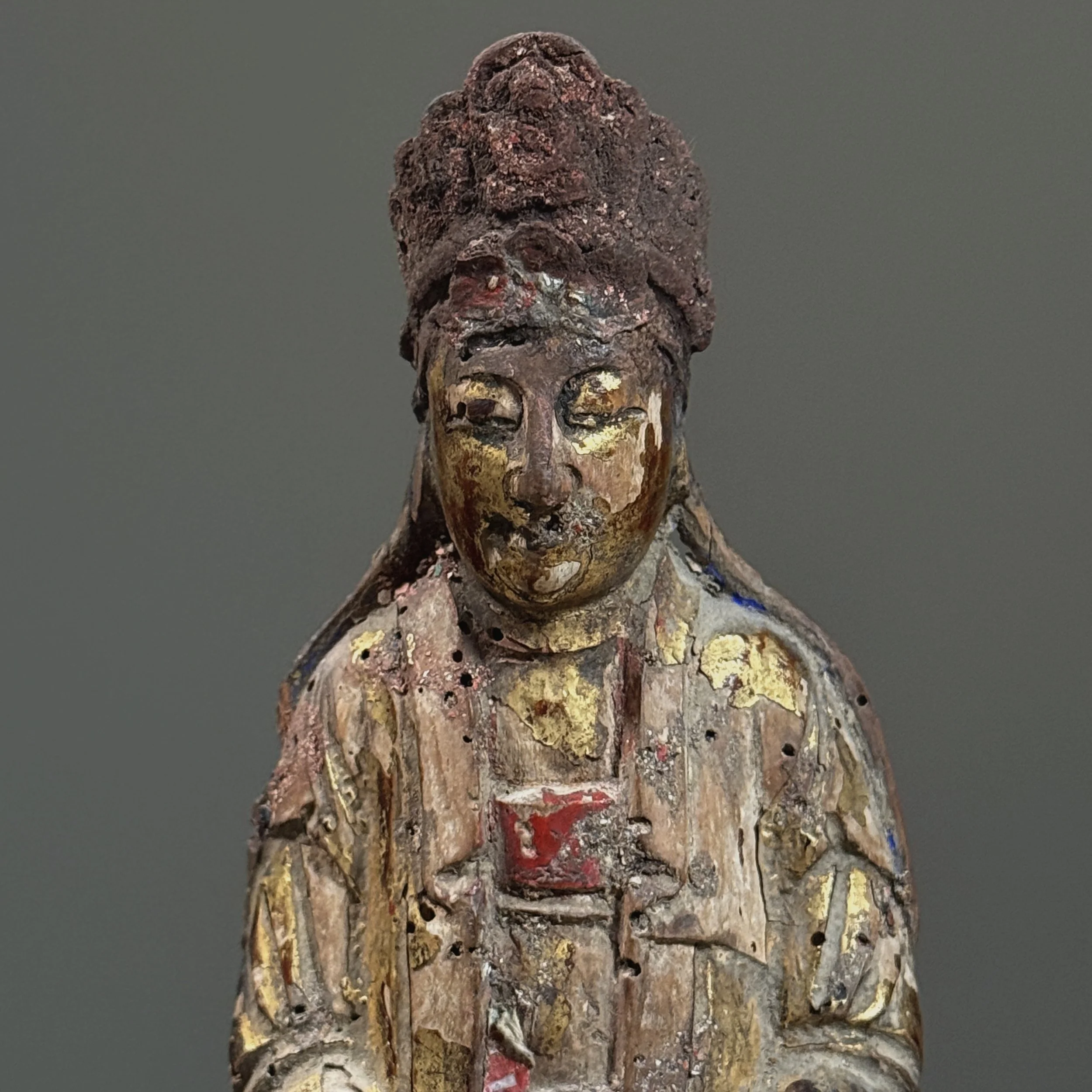 Detail of the face, showing carved features and remnants of gilt.