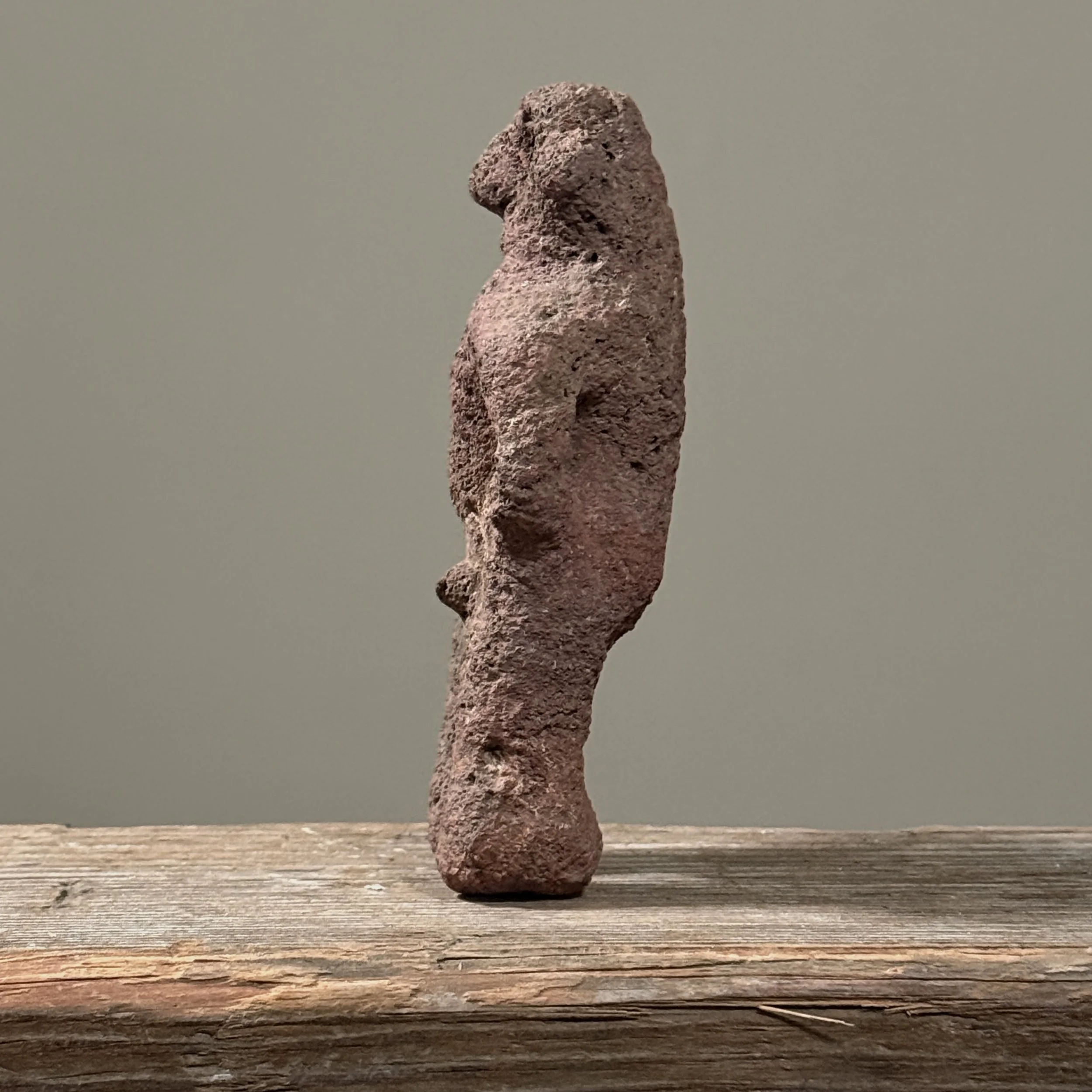 Side view showing the figure's depth and columnar shape.