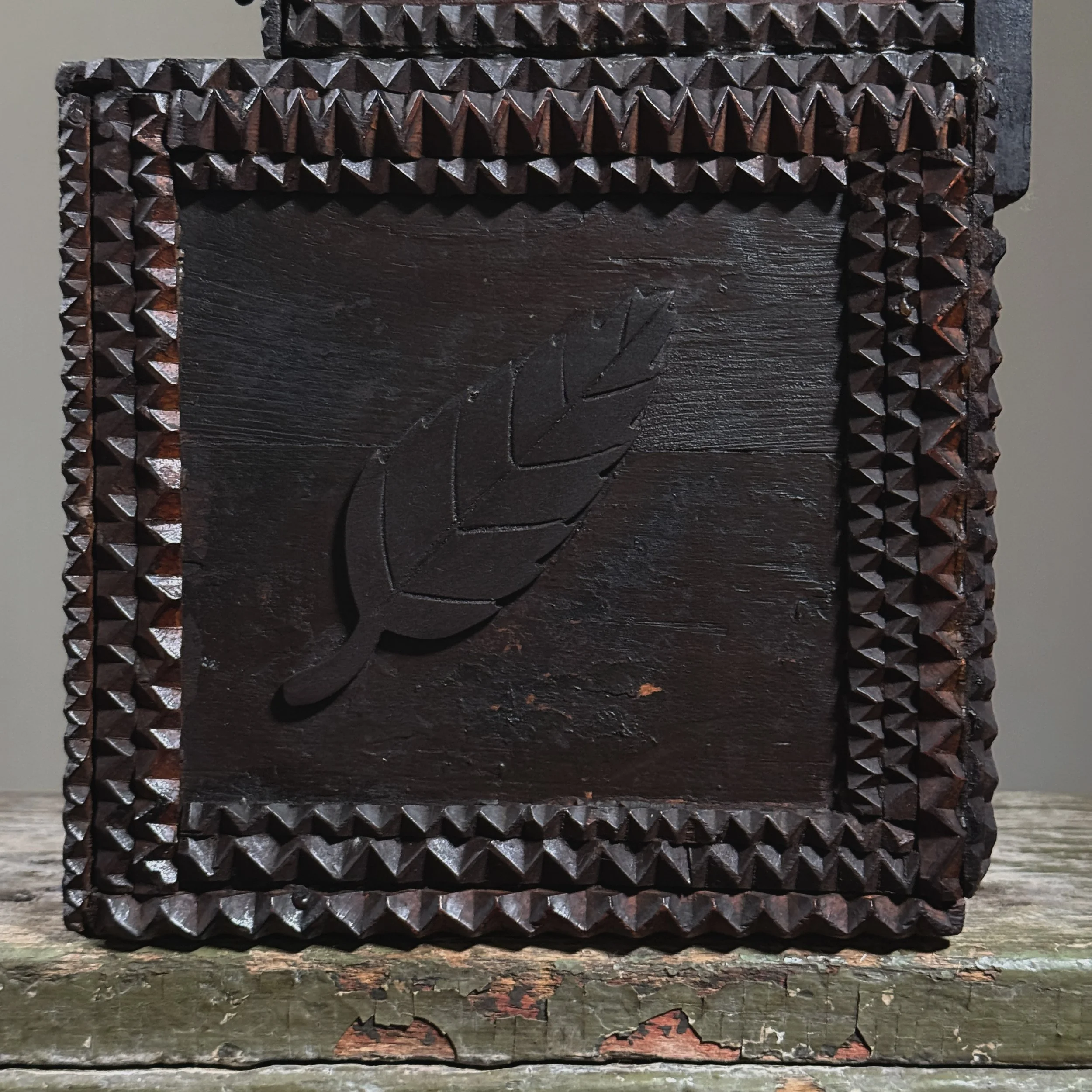 Side view showing the applied chip-carved leaf motif.
