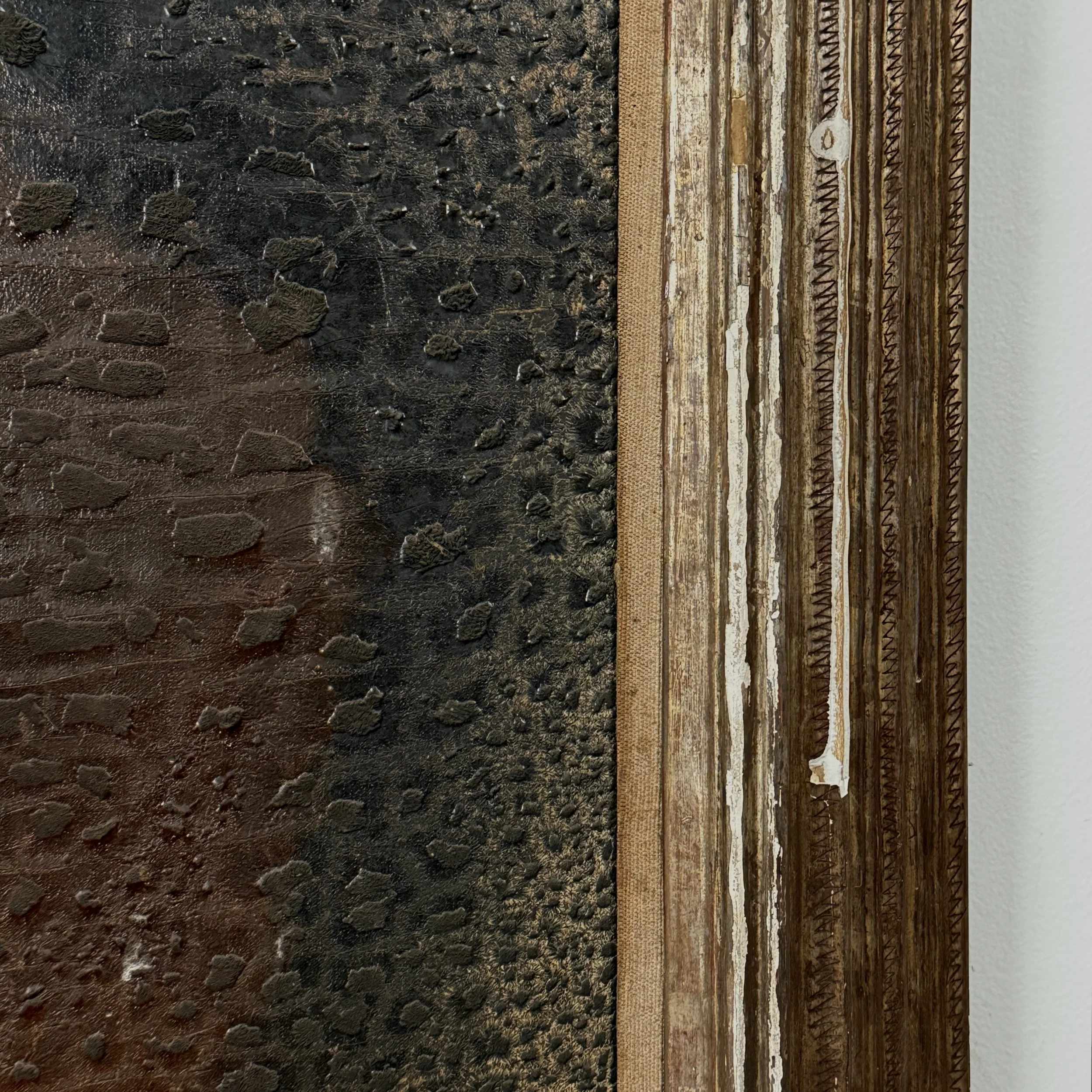 Detail of the frame's corner, showing carving style and losses.