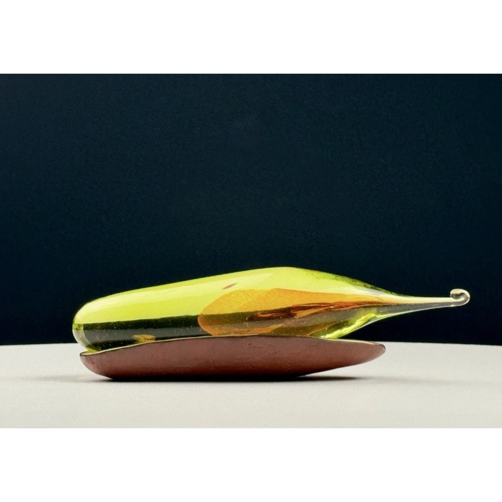 Signed bronzed cradle holding amber, clear and yellow hand-blown glass seed sculpture by Catherine Vamvakas Lay