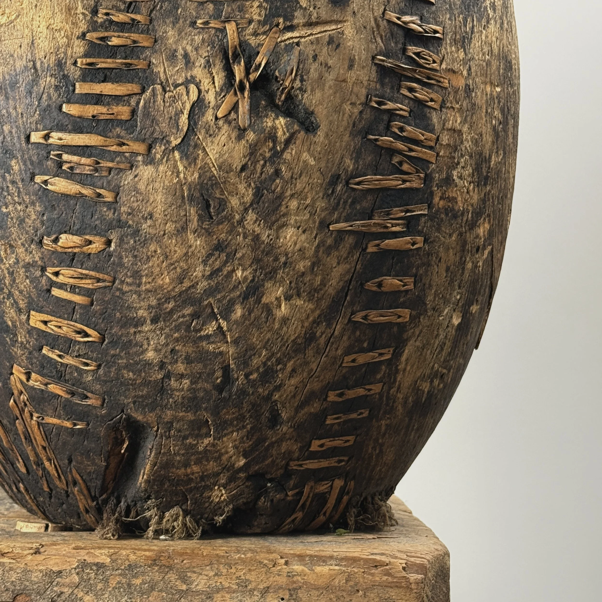 Hand carved wood vessel with visible patination and woven wood inset.