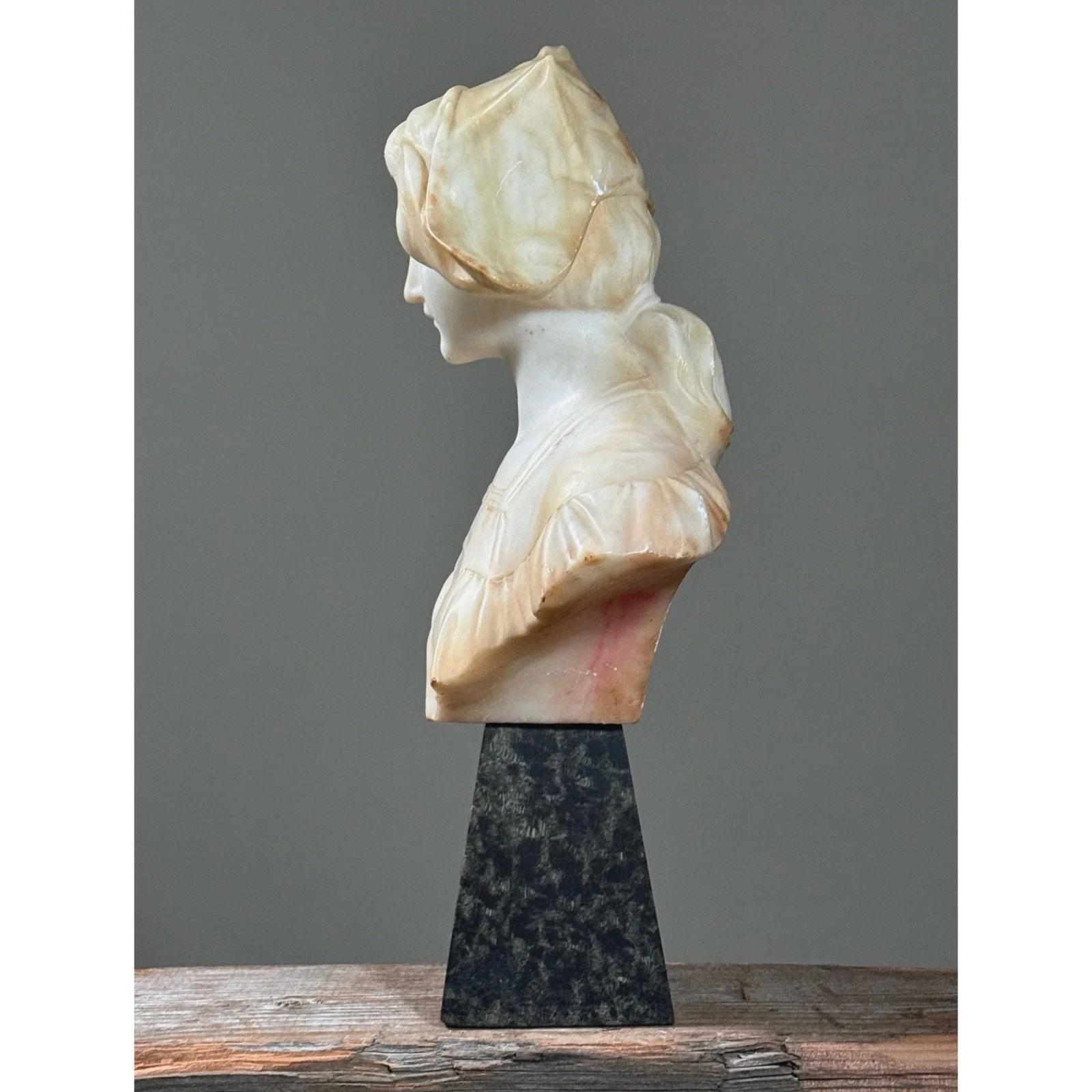 Side view illustrating the relationship between the alabaster bust and the stone stand.