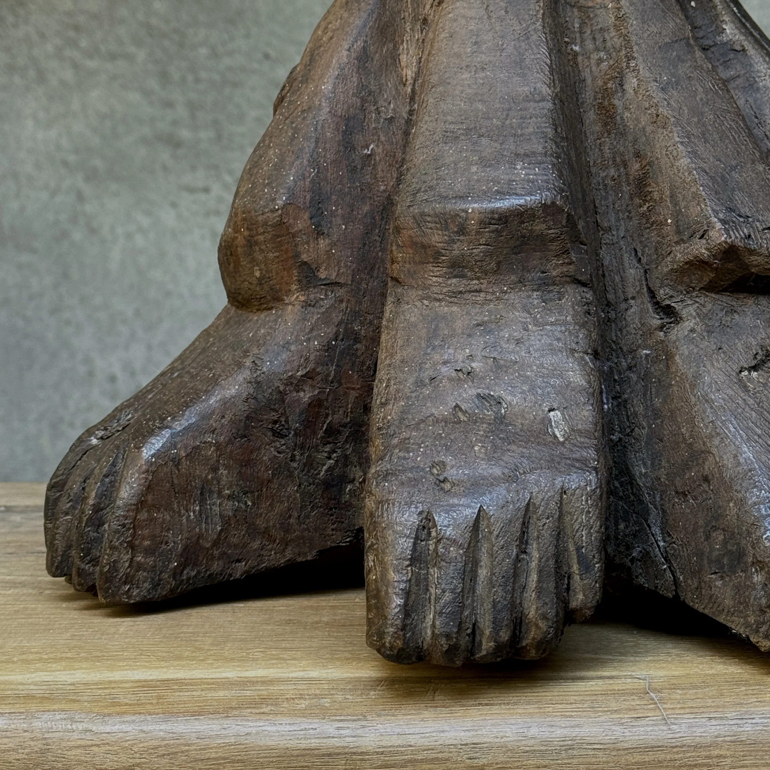 Carved wooden feet at base of sculpture