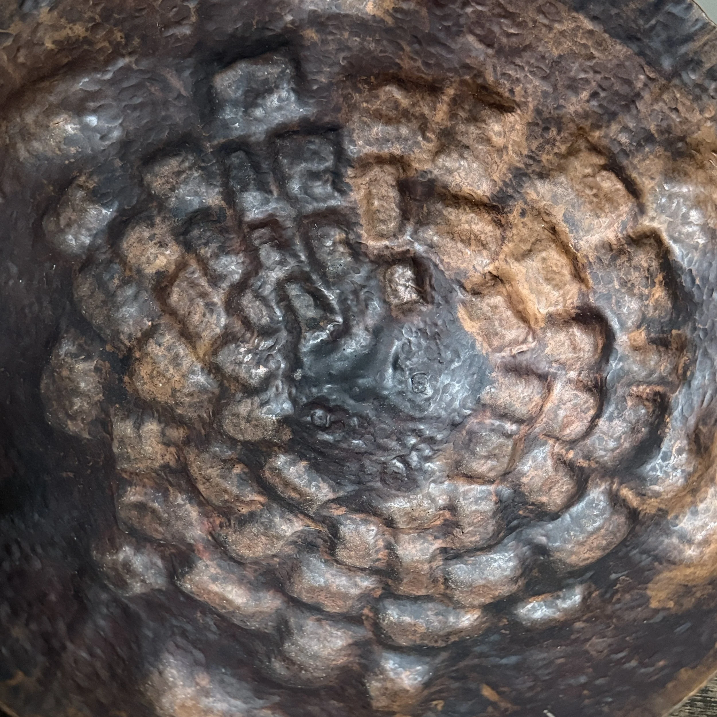 Close-up detail of the dramatic hammered work on the bowl's exterior.