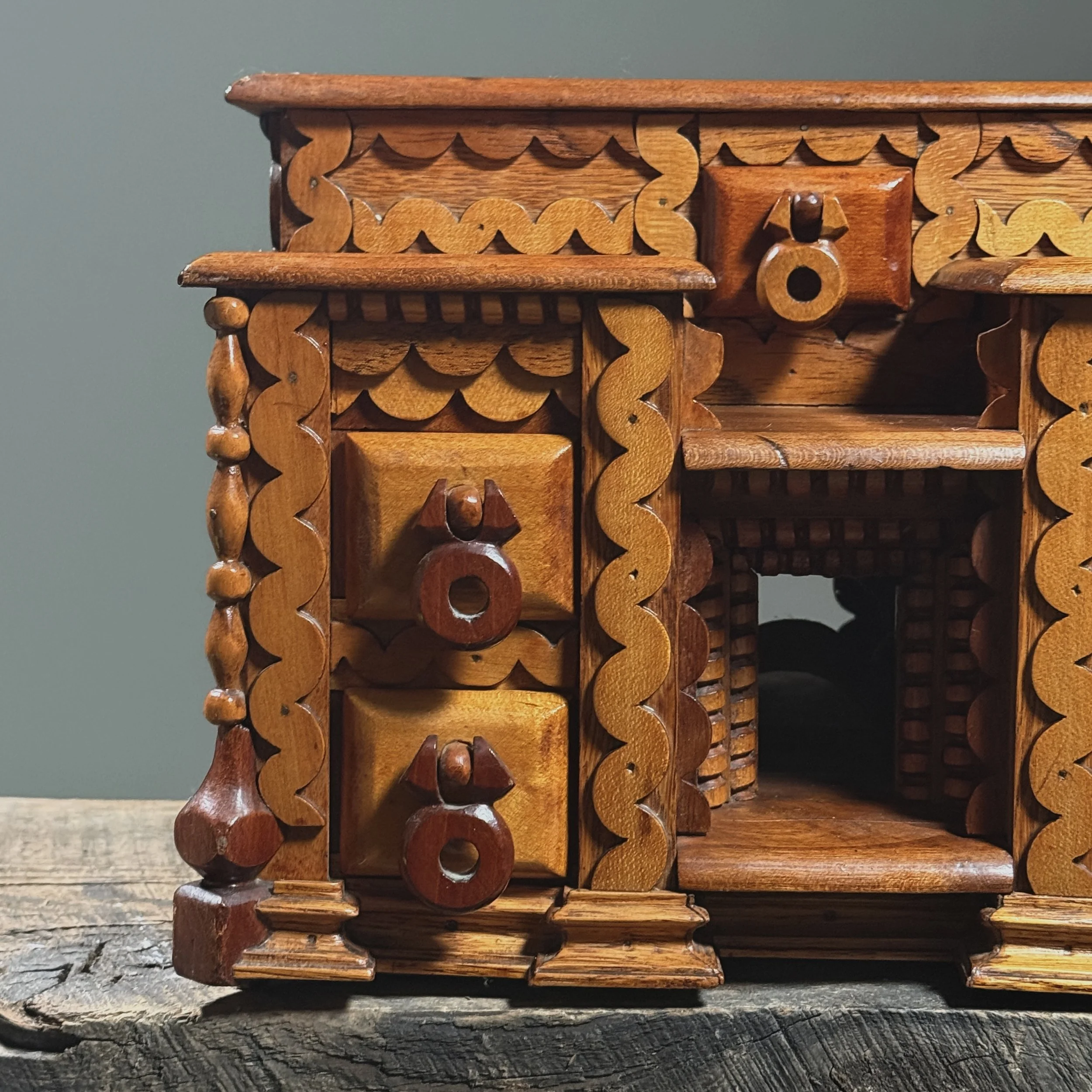 Close-up detail of layered "squiggly" scrollwork ornamentation on a vintage folk art box