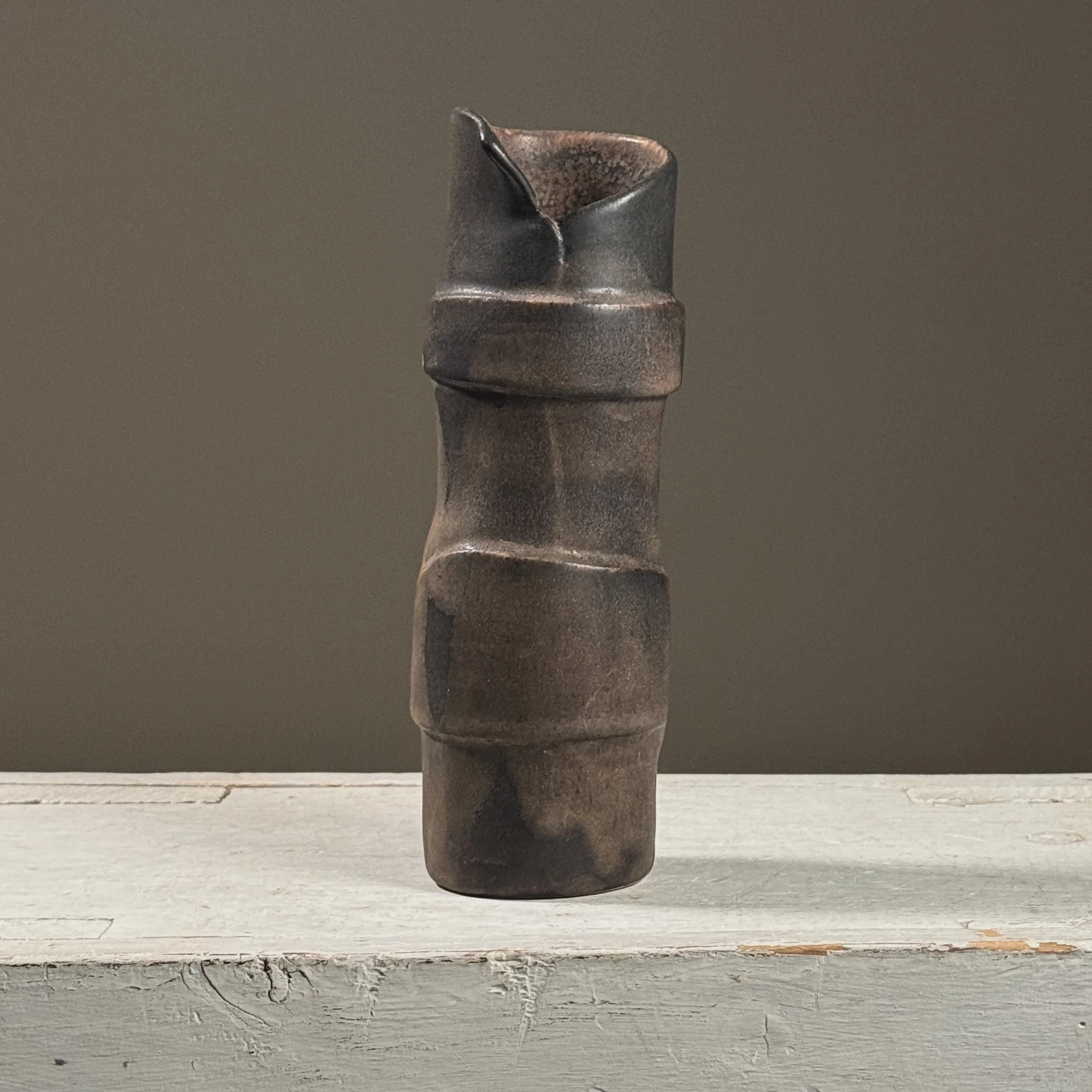Front view of a vintage postmodernist wood-fired black ceramic vase.
