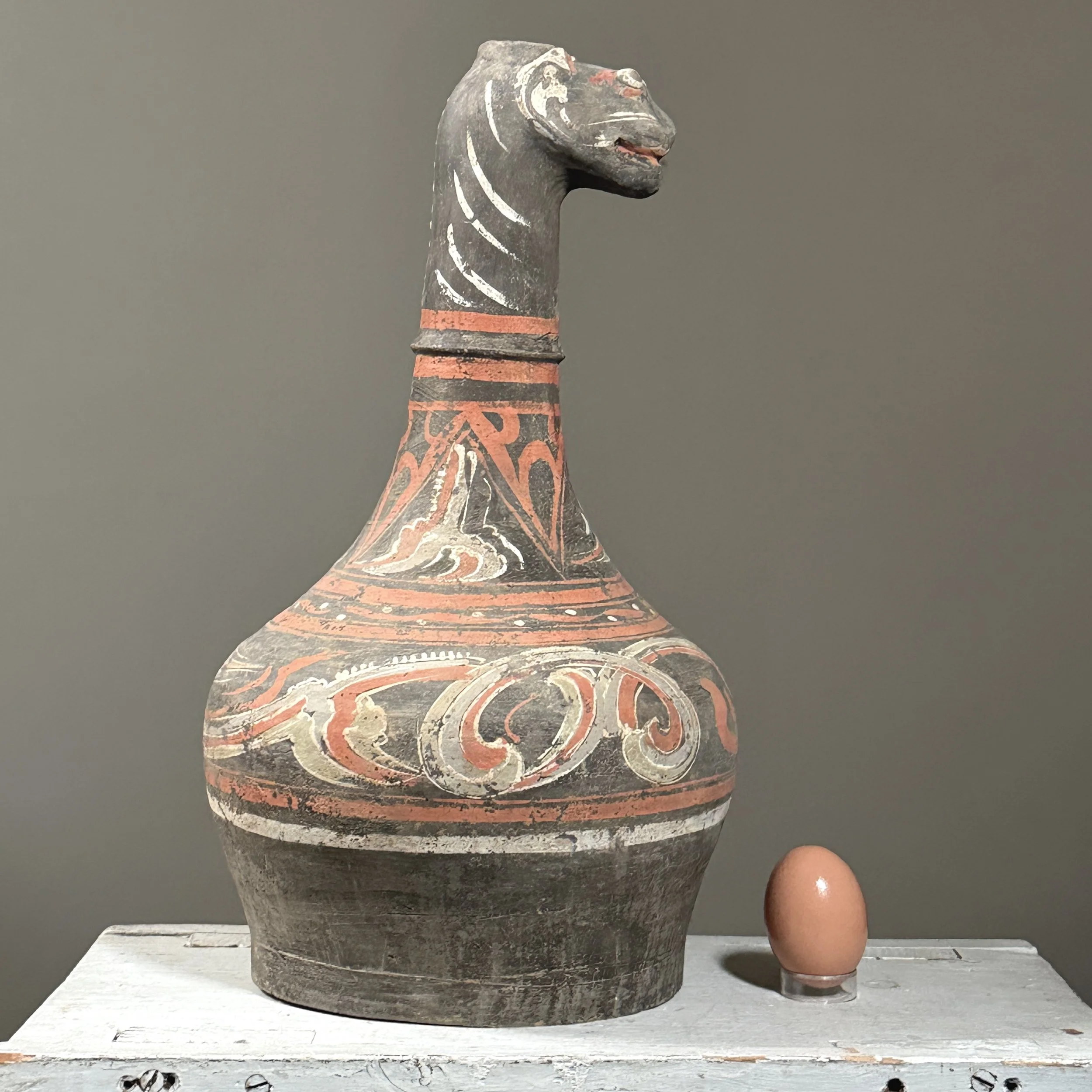 Zoomorphic Chinese vessel with spout shaped as guardian animal with egg for size reference.