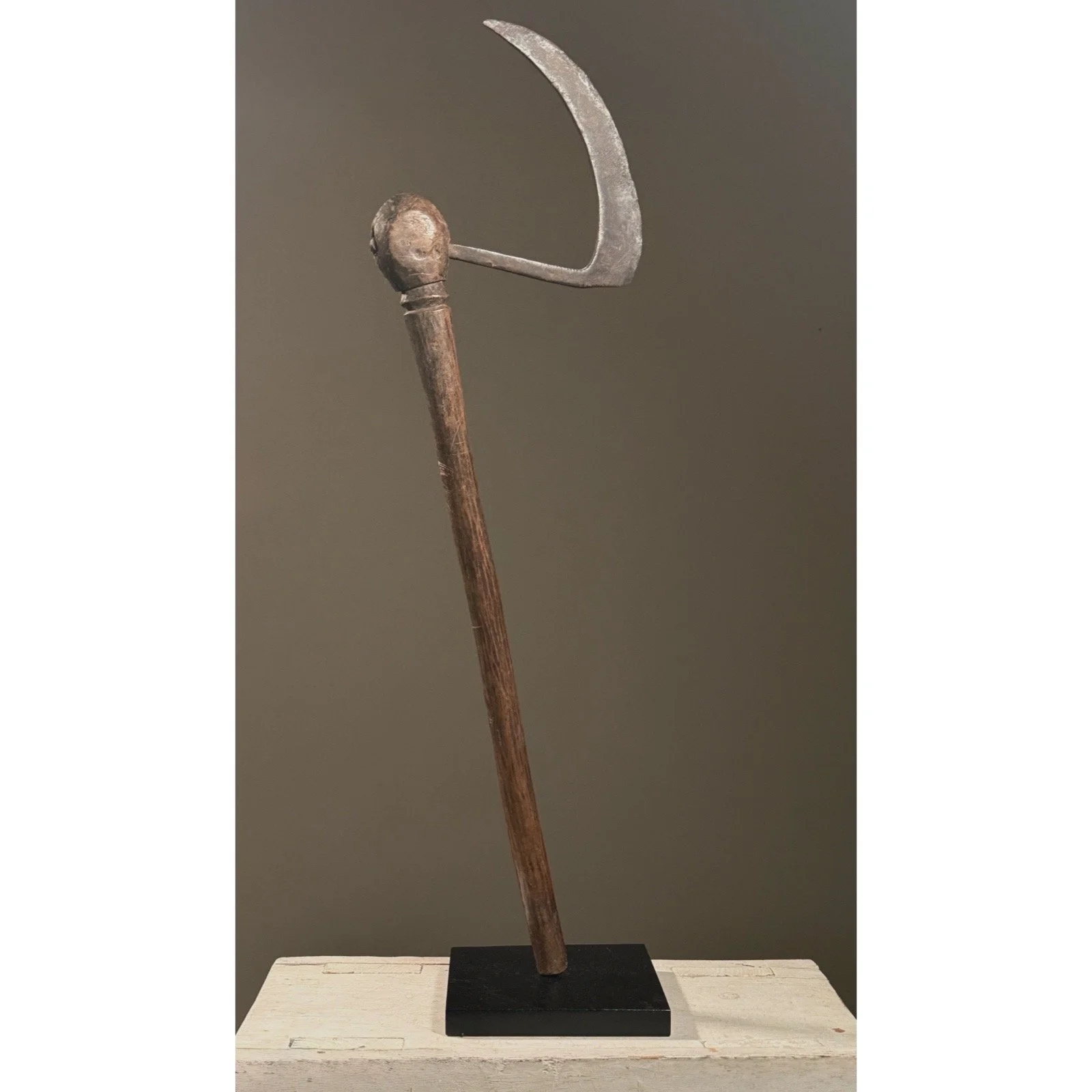 Full frontal view of an antique Bobo ceremonial axe from Burkina Faso with carved face at crux