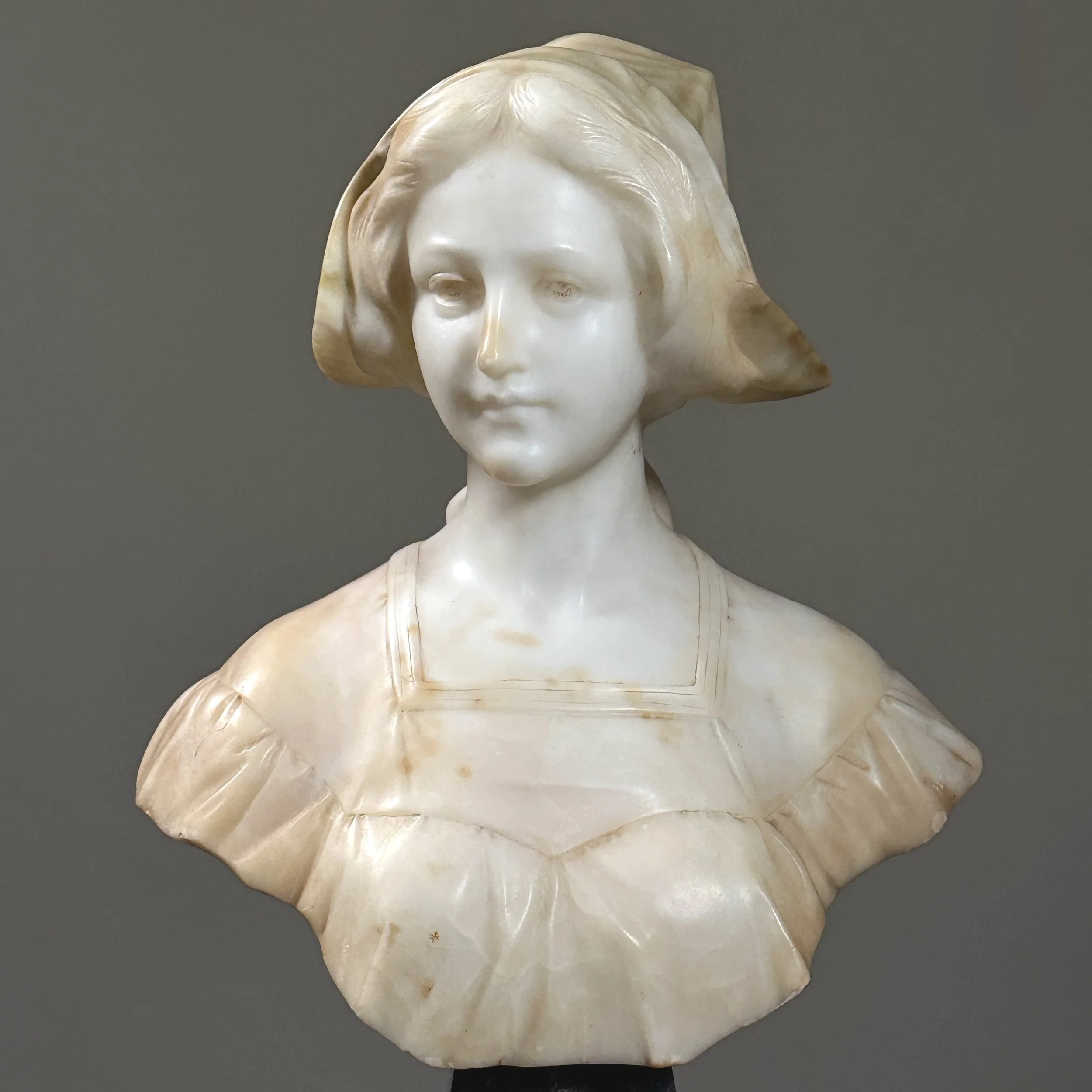 Close-up detail of the woman's softly carved facial features and expression.