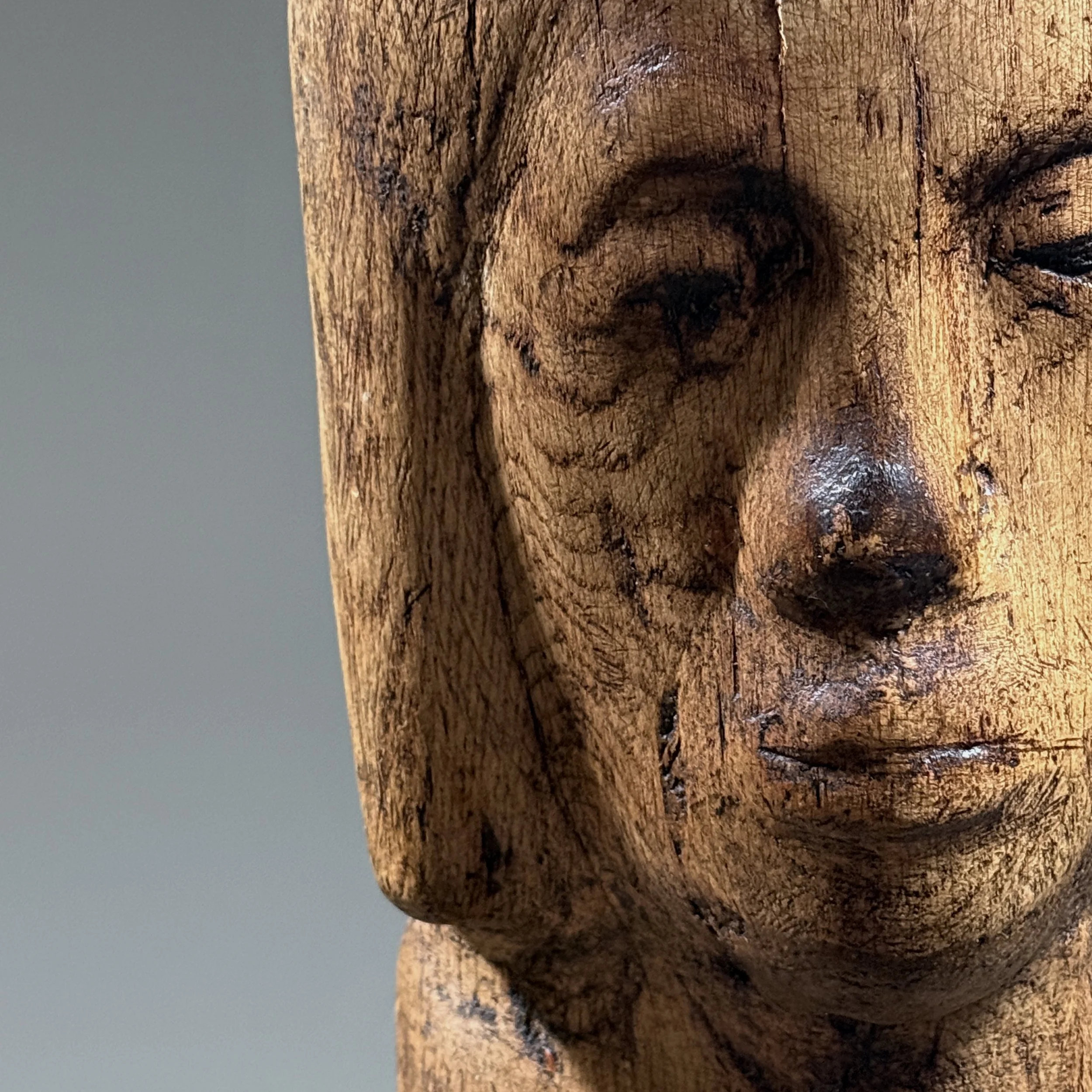 Close-up detail of face and carving on vintage hand carved Folk Art Modernist portrait bust, wood