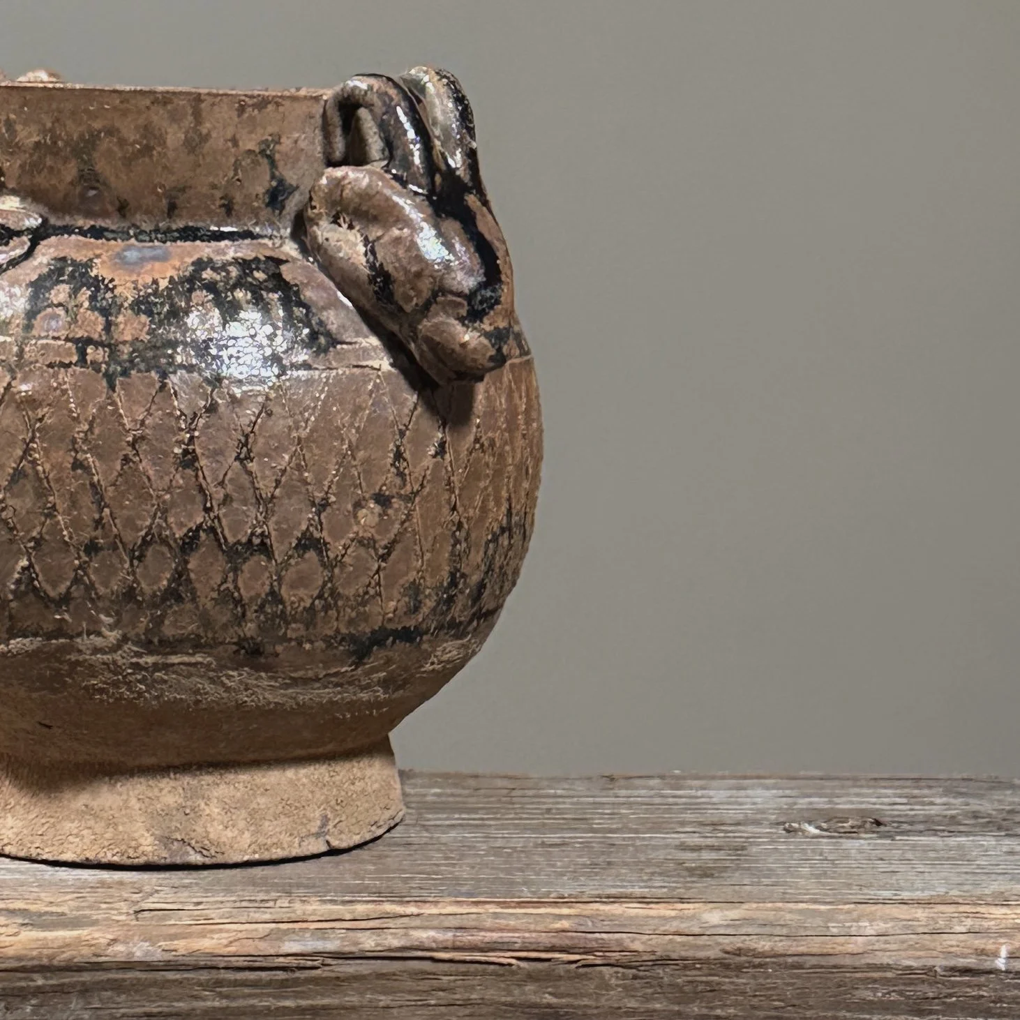 Close-up detail of one of the applied ram-head handles below the jar's rim.