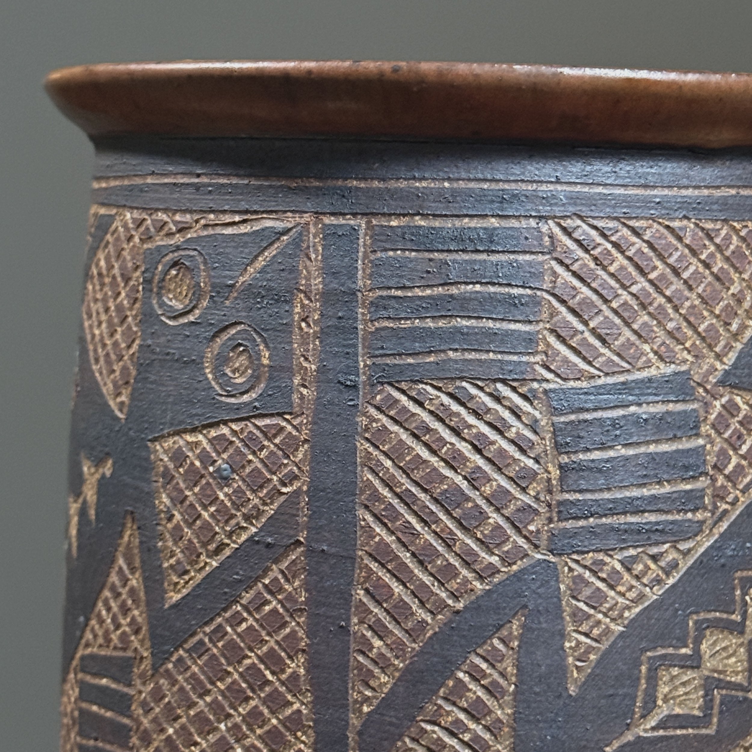 Close-up detail of hand-incised sgraffito lizard design on a vintage ceramic vessel by Tinsman