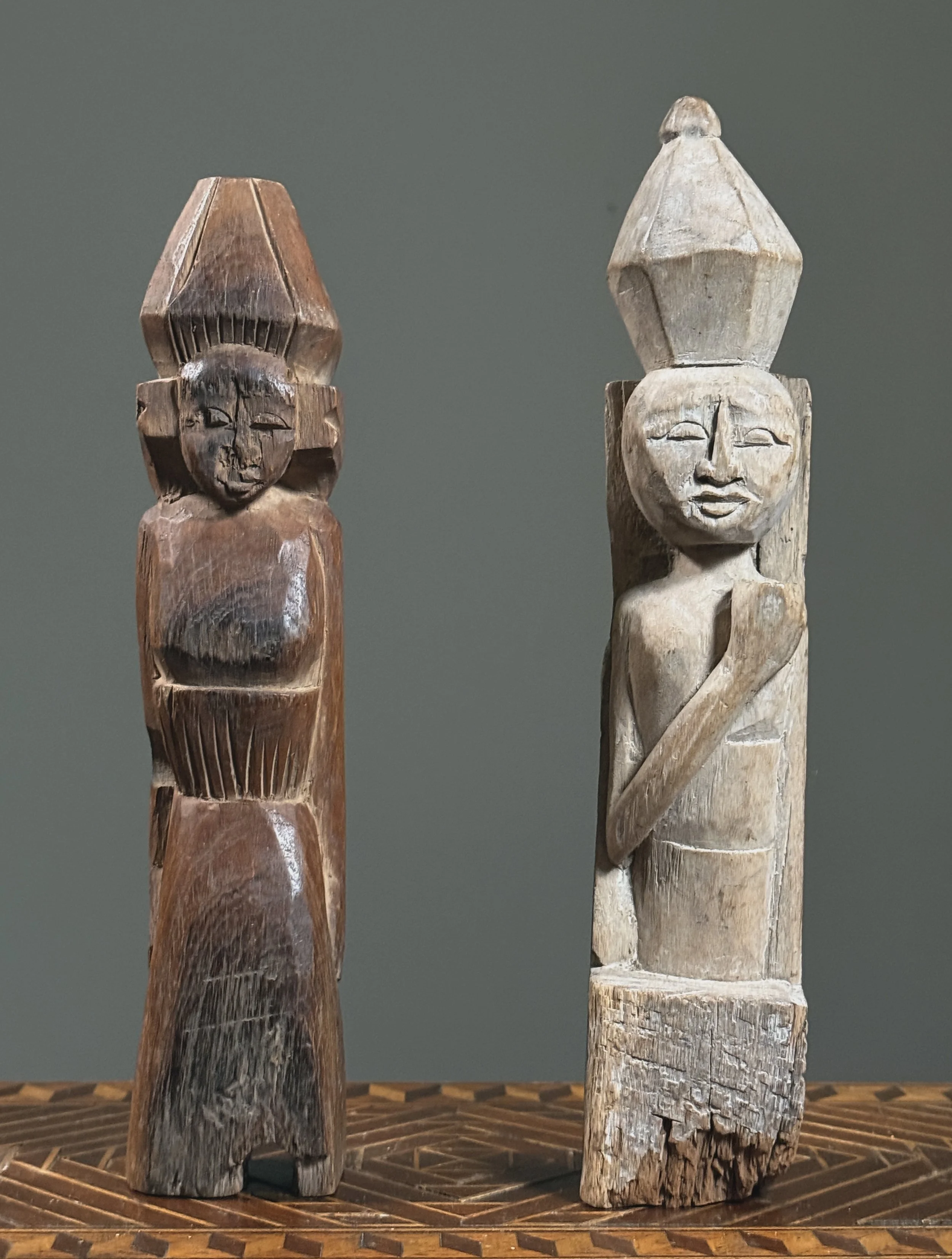 Antique hand-carved folk art figures on neutral background
