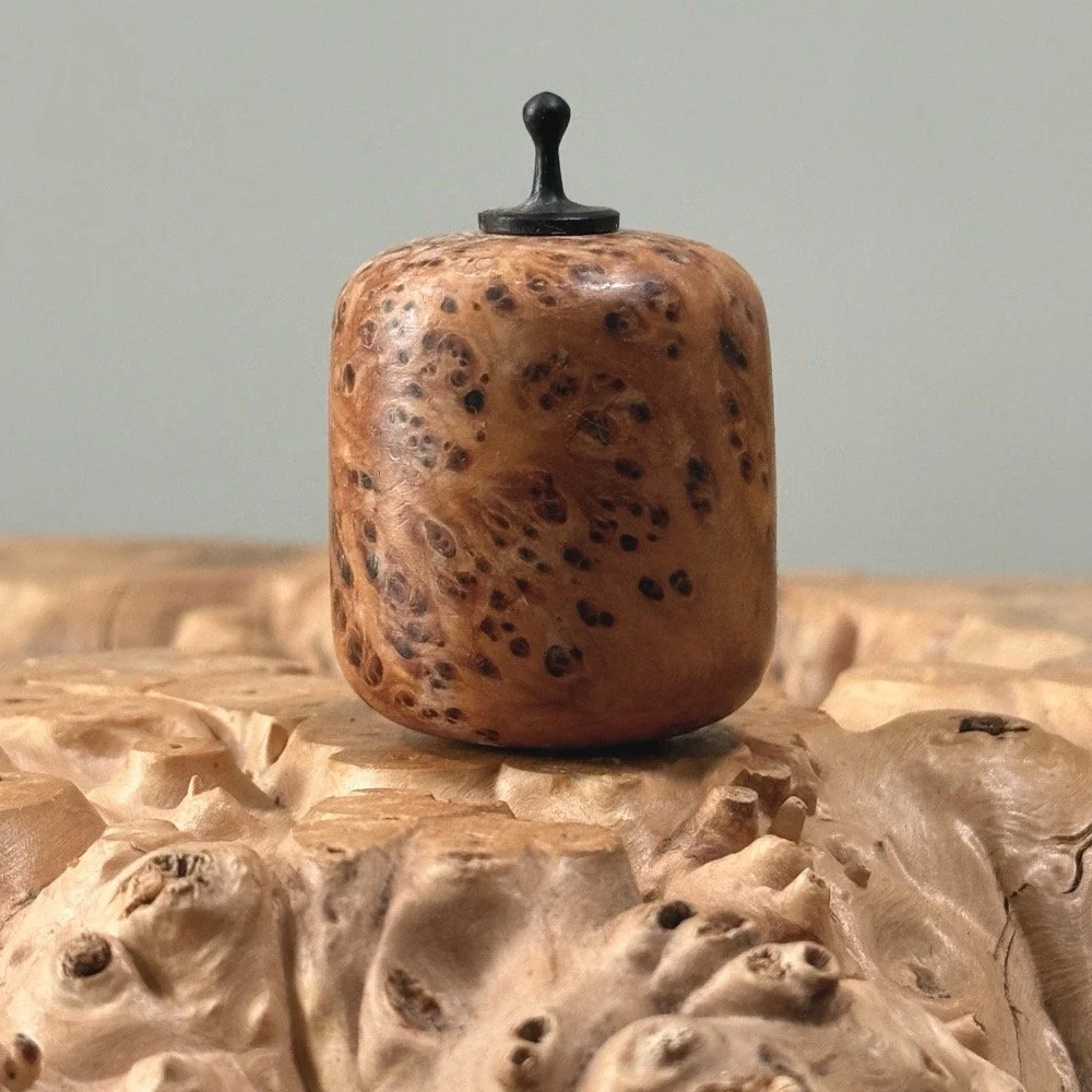 Vintage hand turned cherry burl wood miniature vessel with ebony finial on white background.