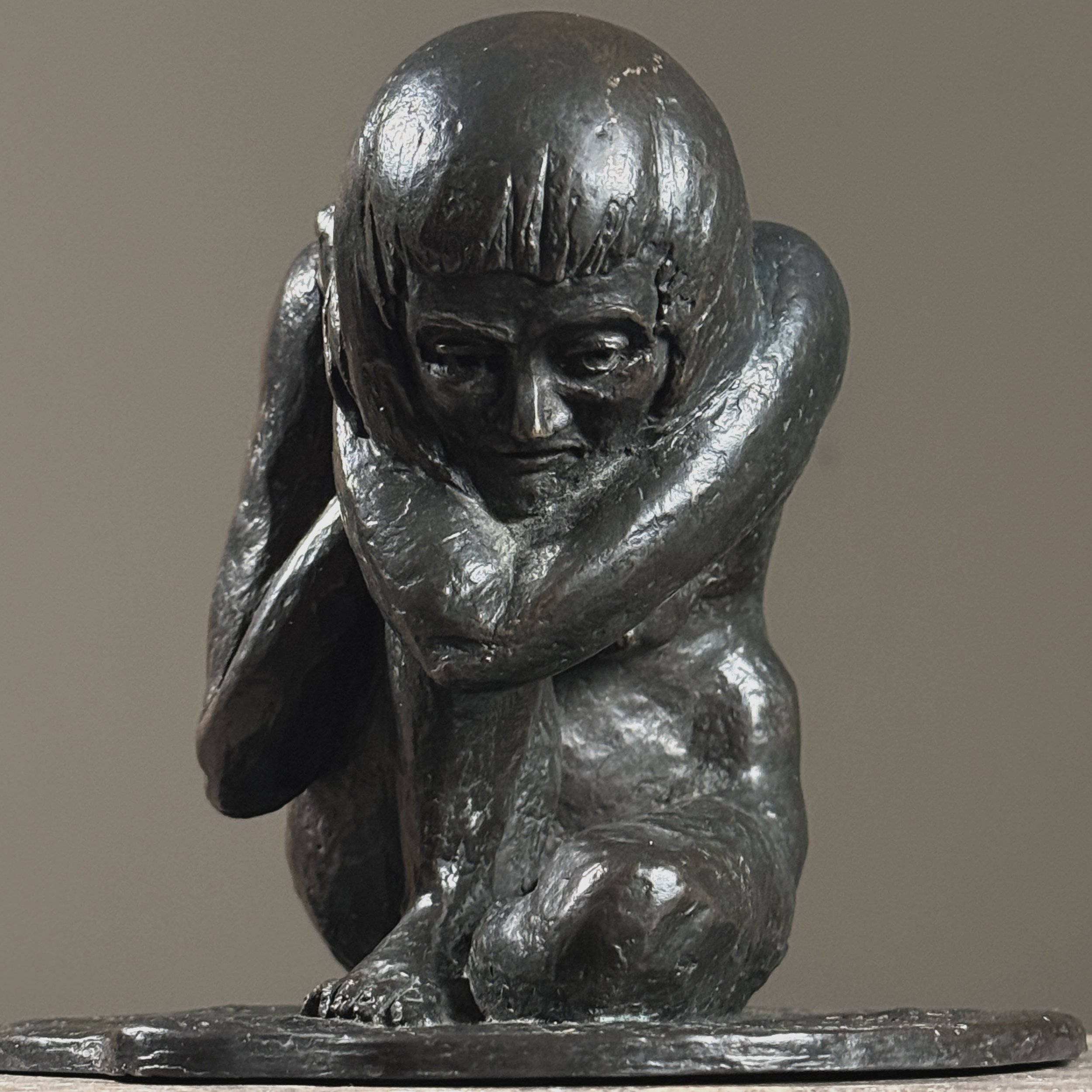 Close-up detail of the crouching nude's form and naturalistic anatomical modeling