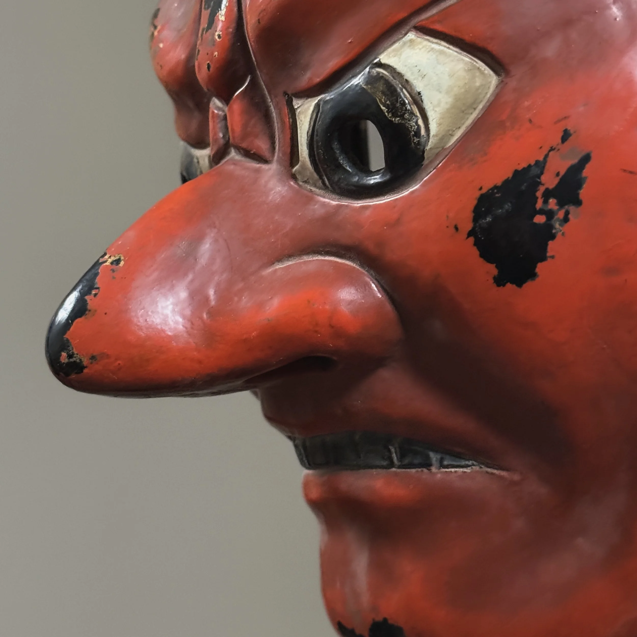 Face close-up. Wide grinning mouth. Teeth. Furrowed brows.