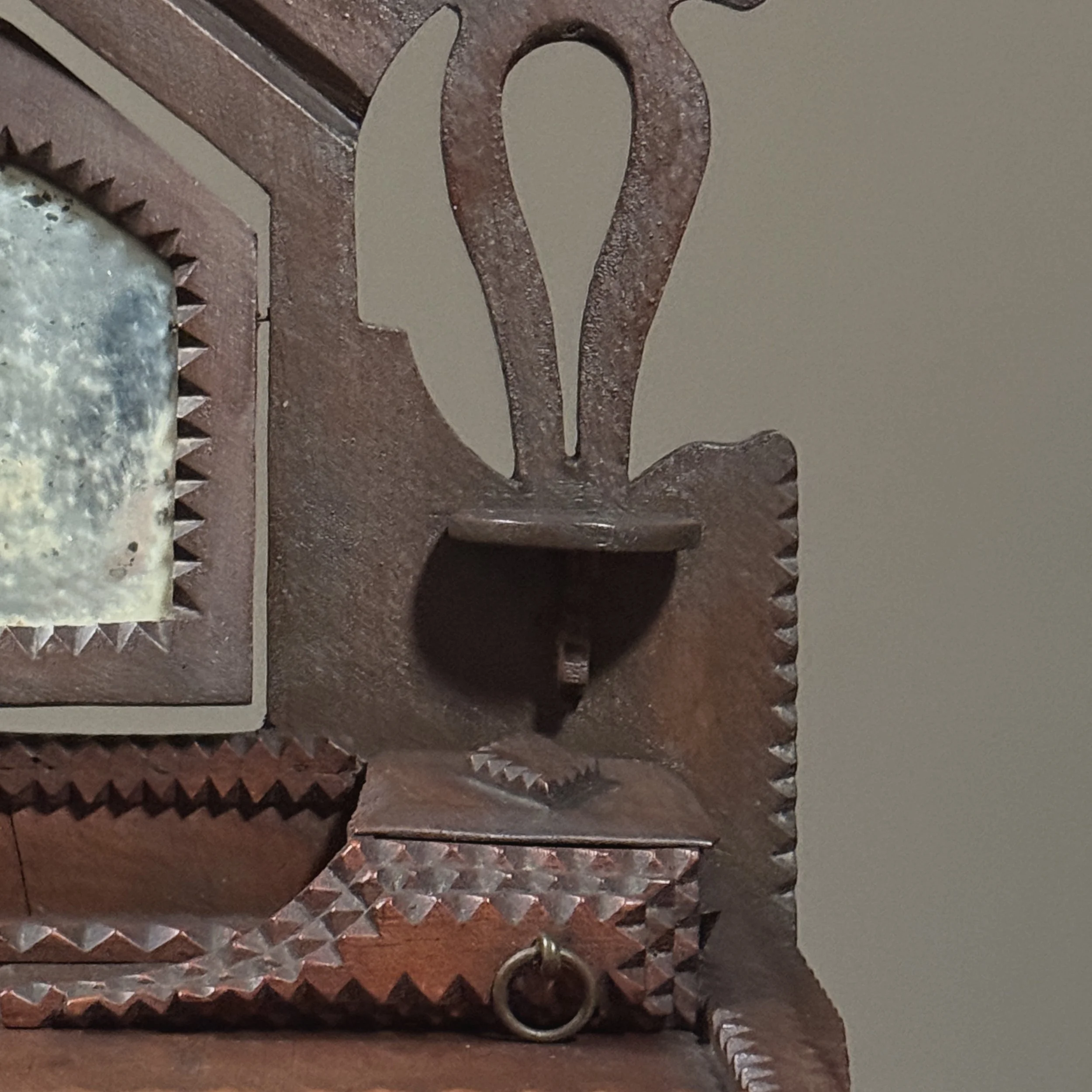 Horseshoe-shaped carvings on backboard beside mirror