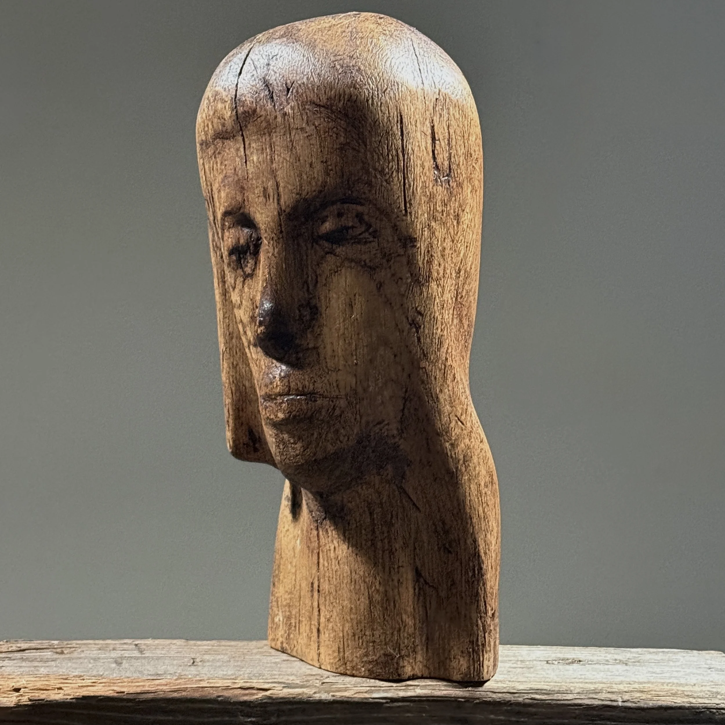 Three-quarter view of hand carved wood portrait bust in Folk Art Modernist style, vintage, deep patina