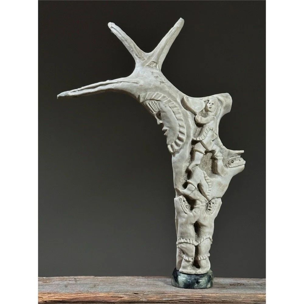 Full view of a vintage Inuit folk art antler sculpture with figures and moon.
