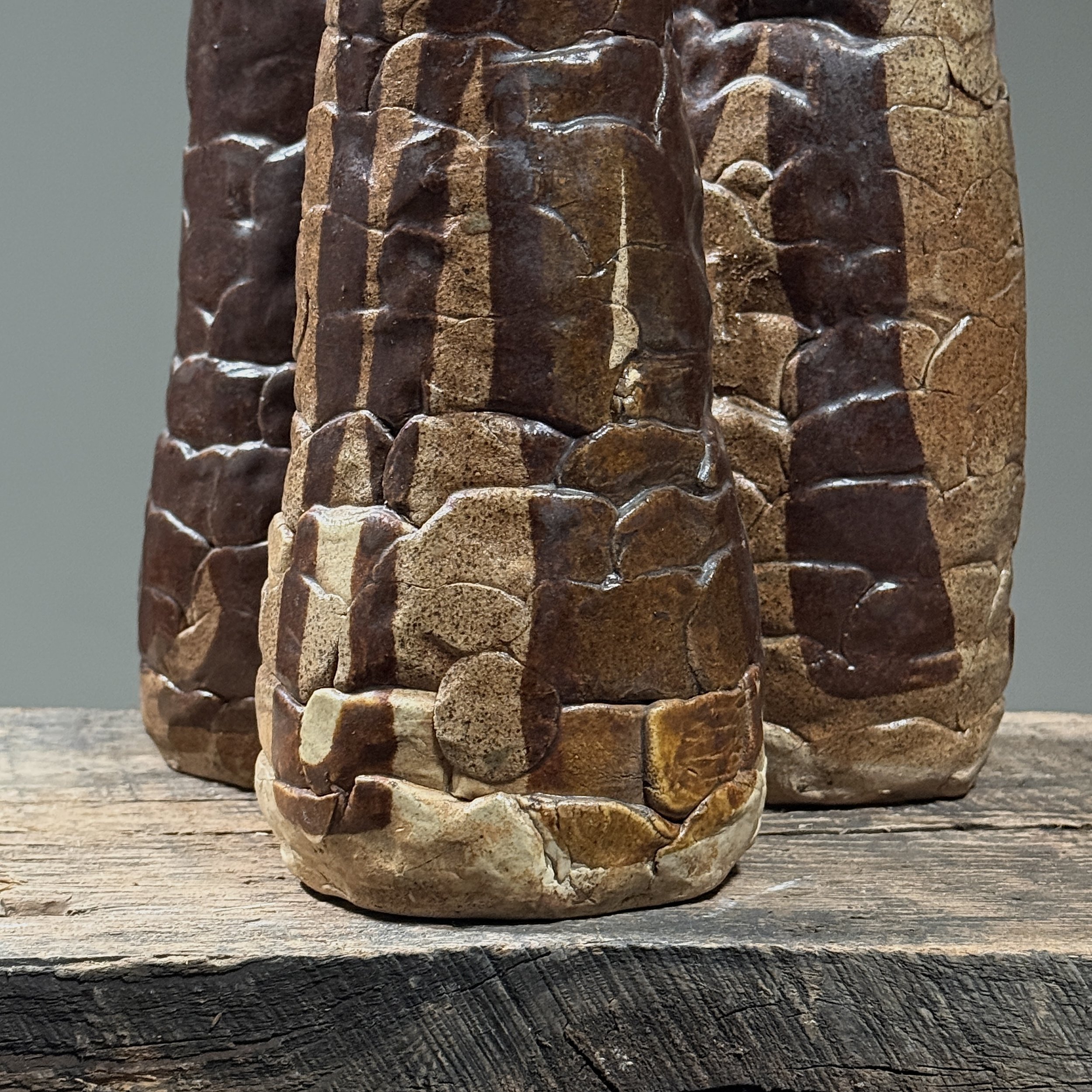 Close-up detail of hand-built construction and textured brown glaze on a Brutalist ceramic vessel
