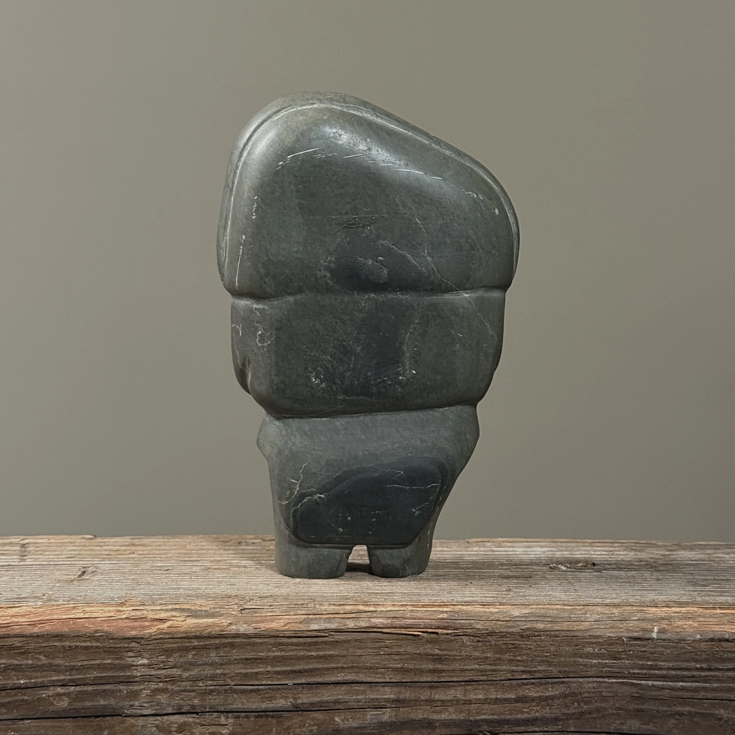 Back view of hand-carved Inuit sculpture in grey stone