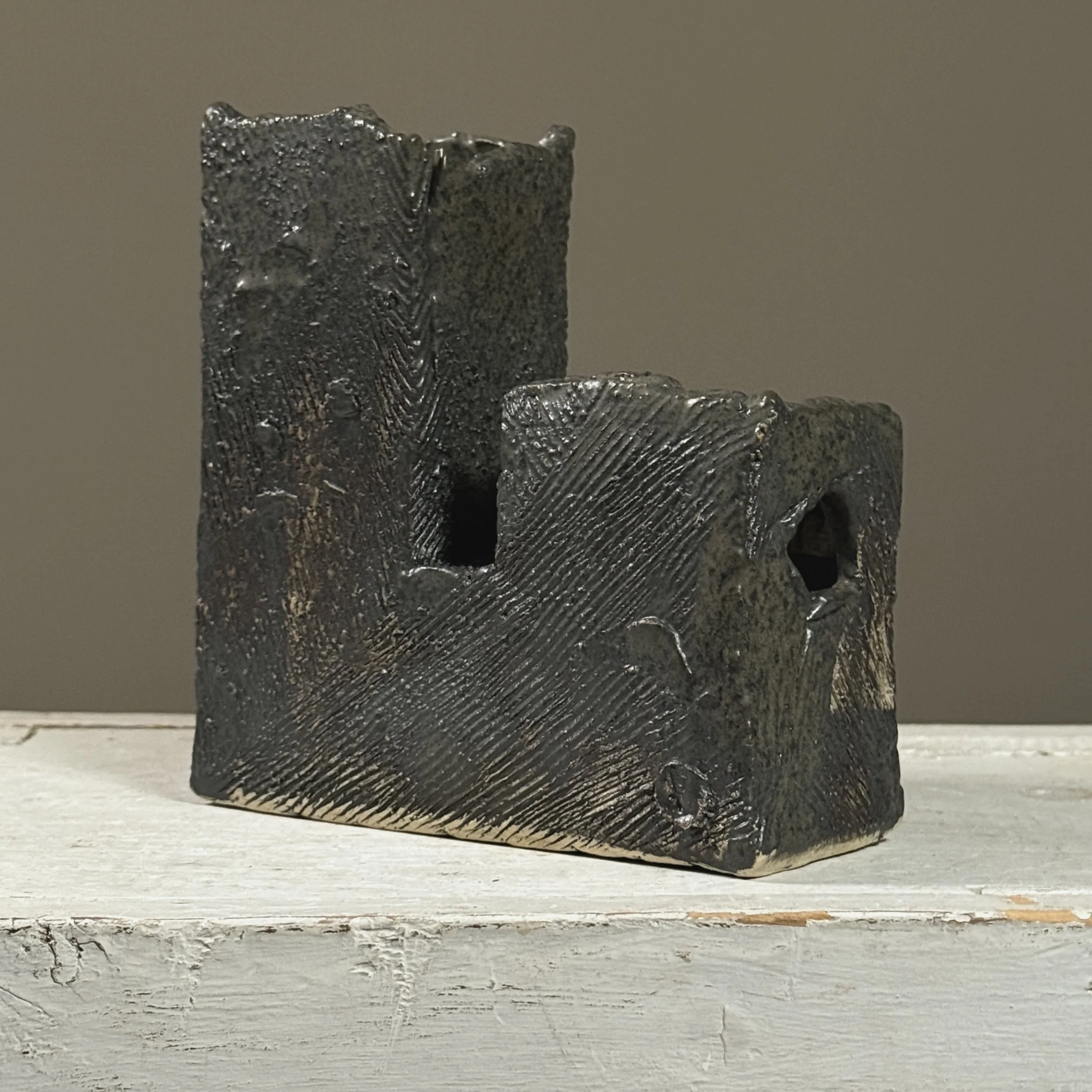 Smaller Brutalist vessel with openwork cutouts, 3/4 view.