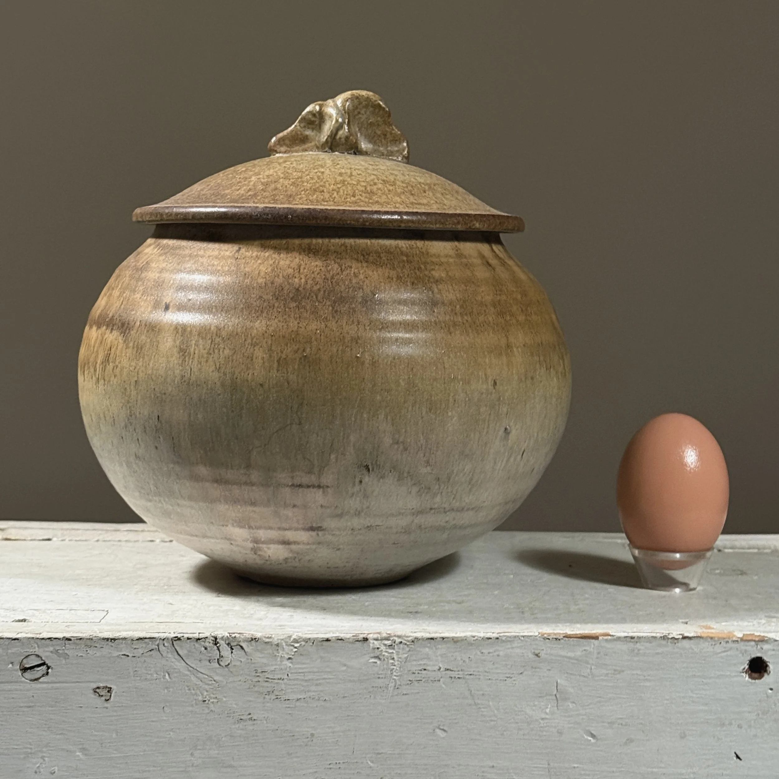 Lidded vessel with an egg for size reference.